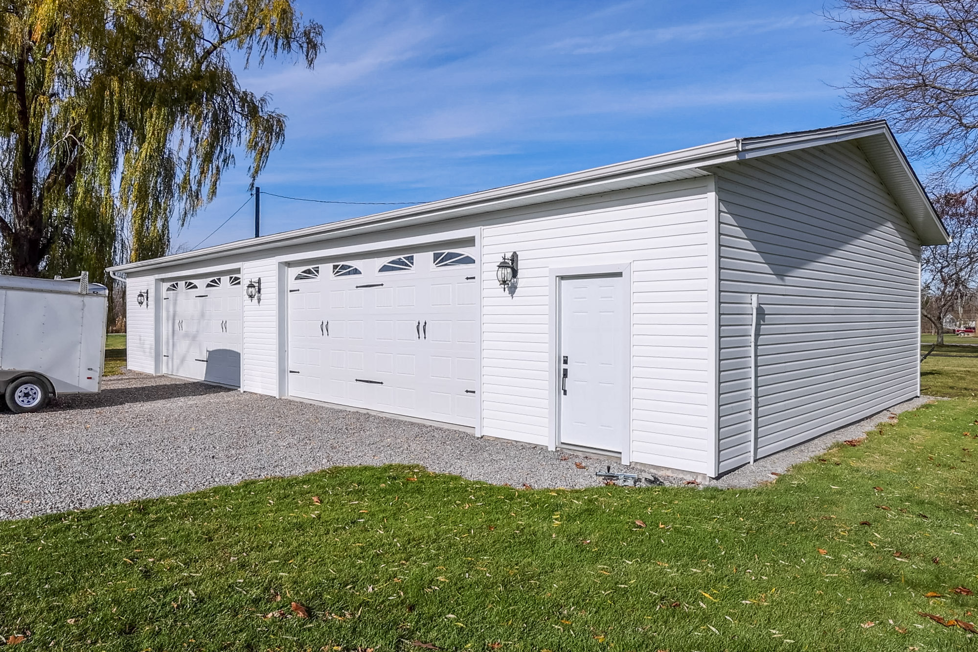 A large white building with a driveway next to a grassy area