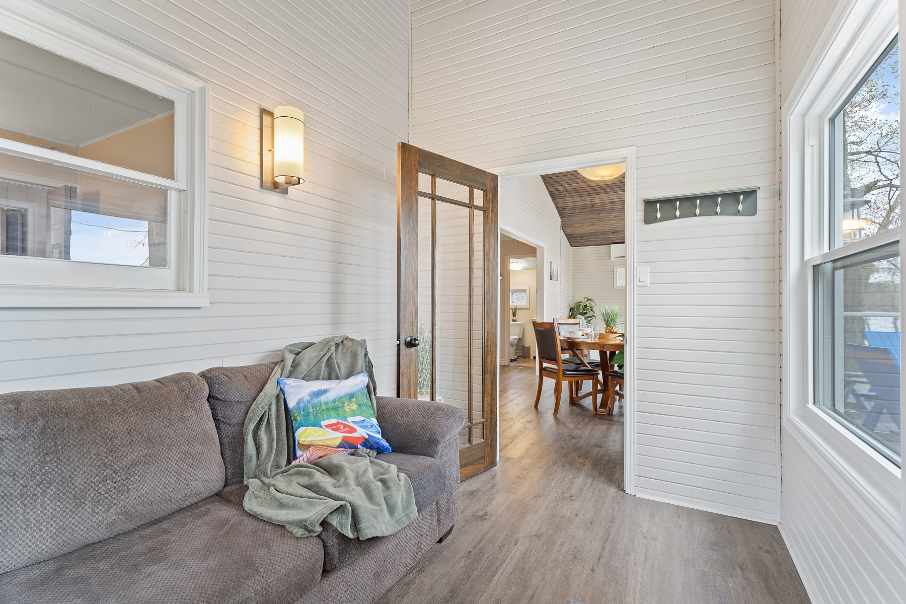 A sunroom with an open doorway into a dining area.