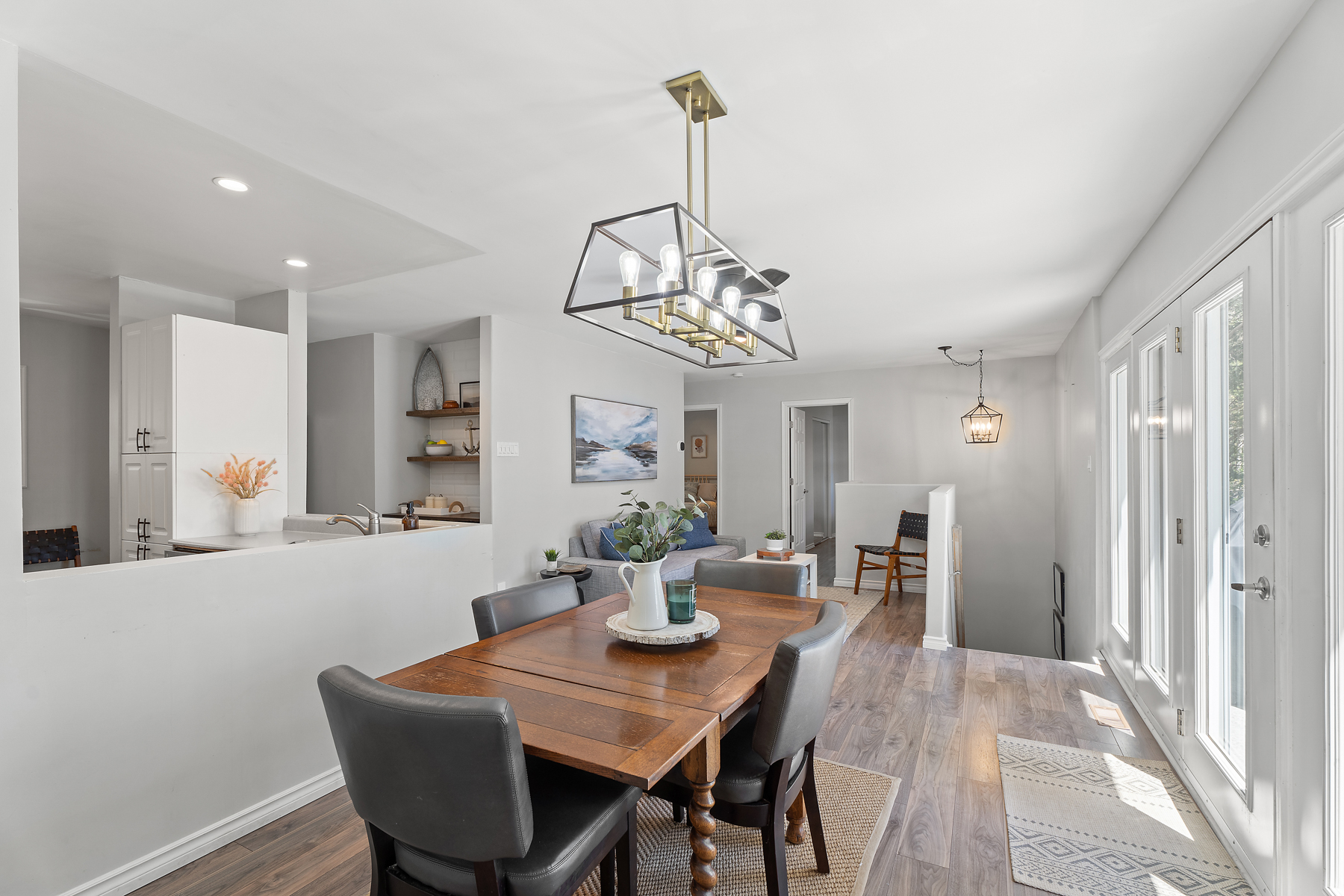 A small brown dining table with four chairs looks out onto the lake