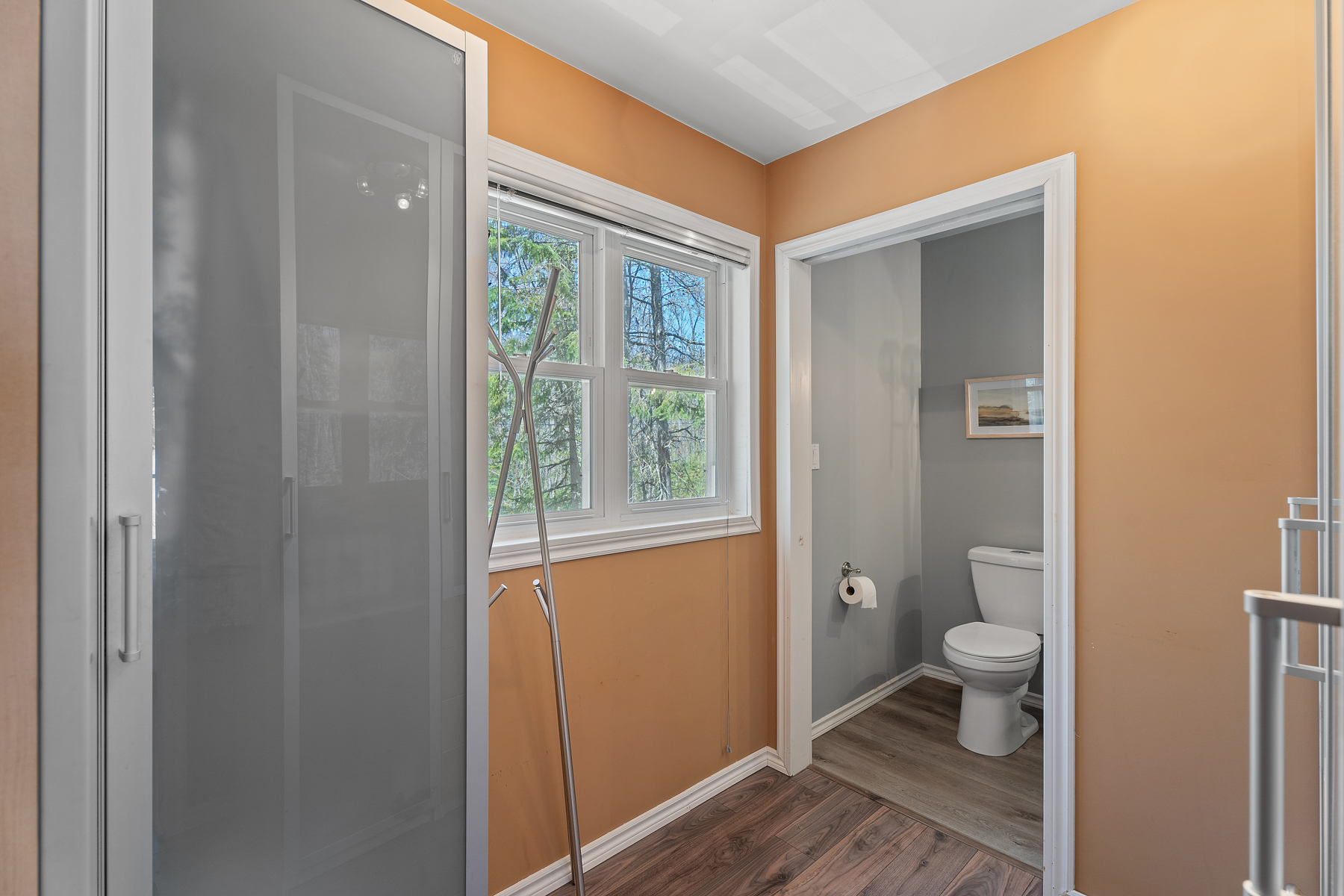 Orange walls frame the entrance to a grey bathroom