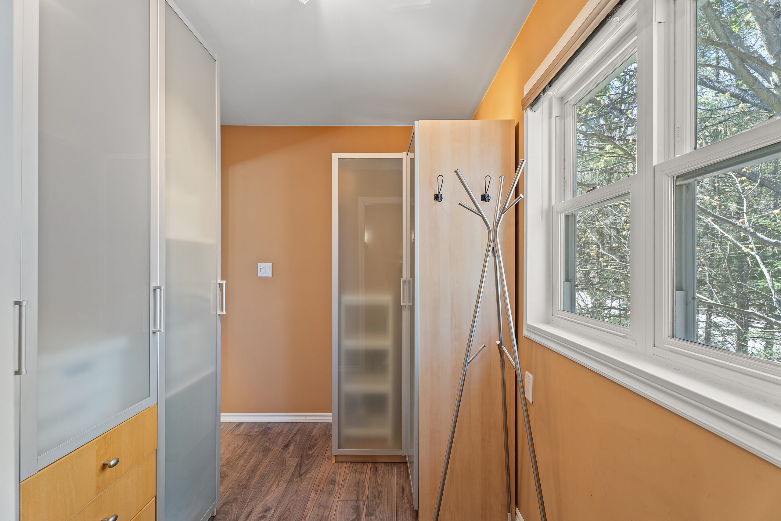 a walk-in closet with tan-coloured walls