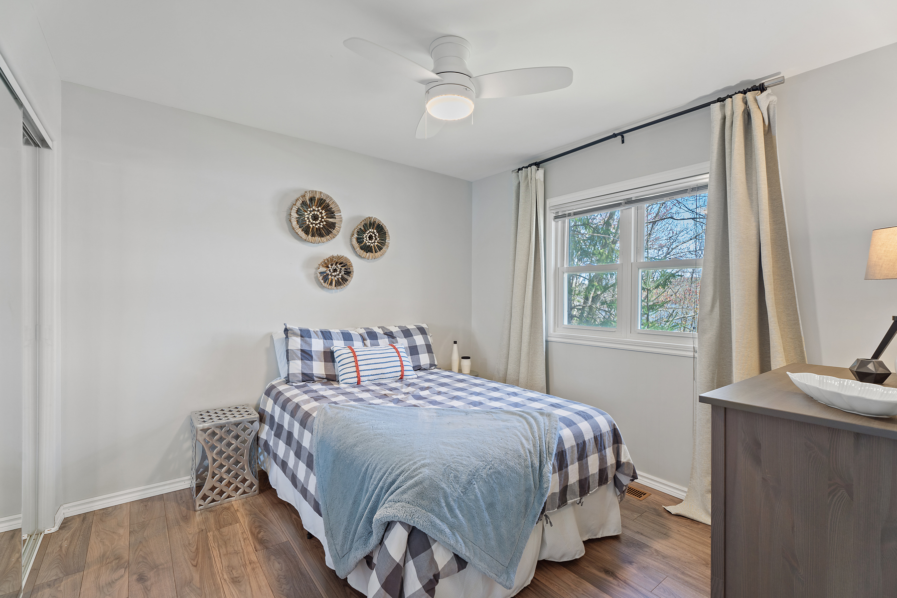 A bed with blue and white checkers next to a window