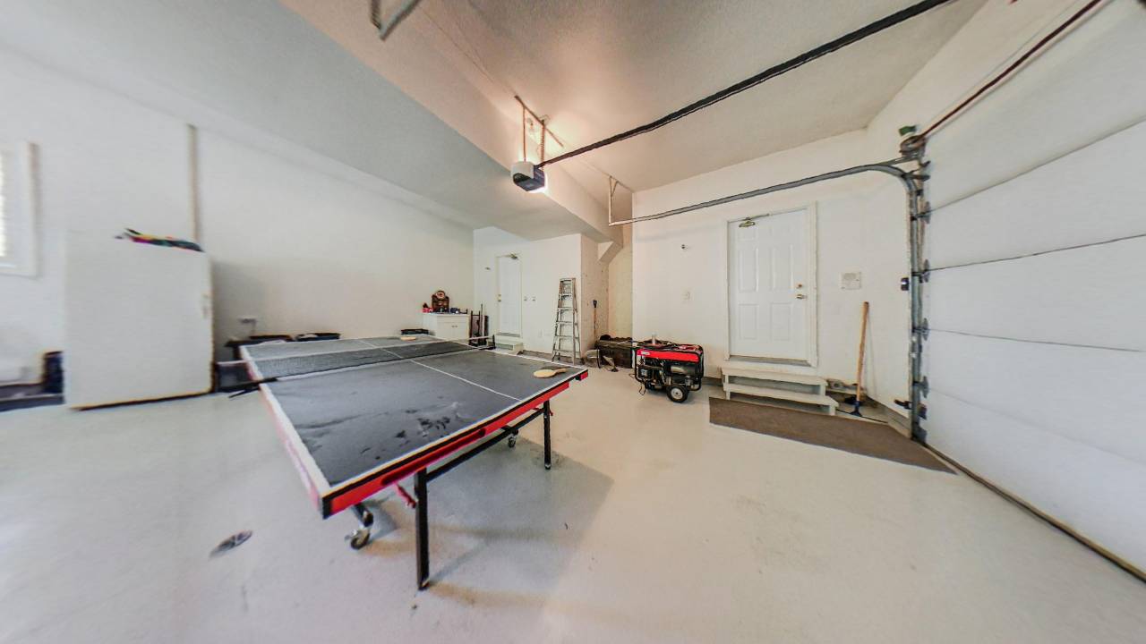 Inside an unfinished garage is a ping-pong table