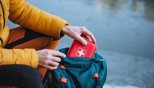 Person putting first aid kit into a bag