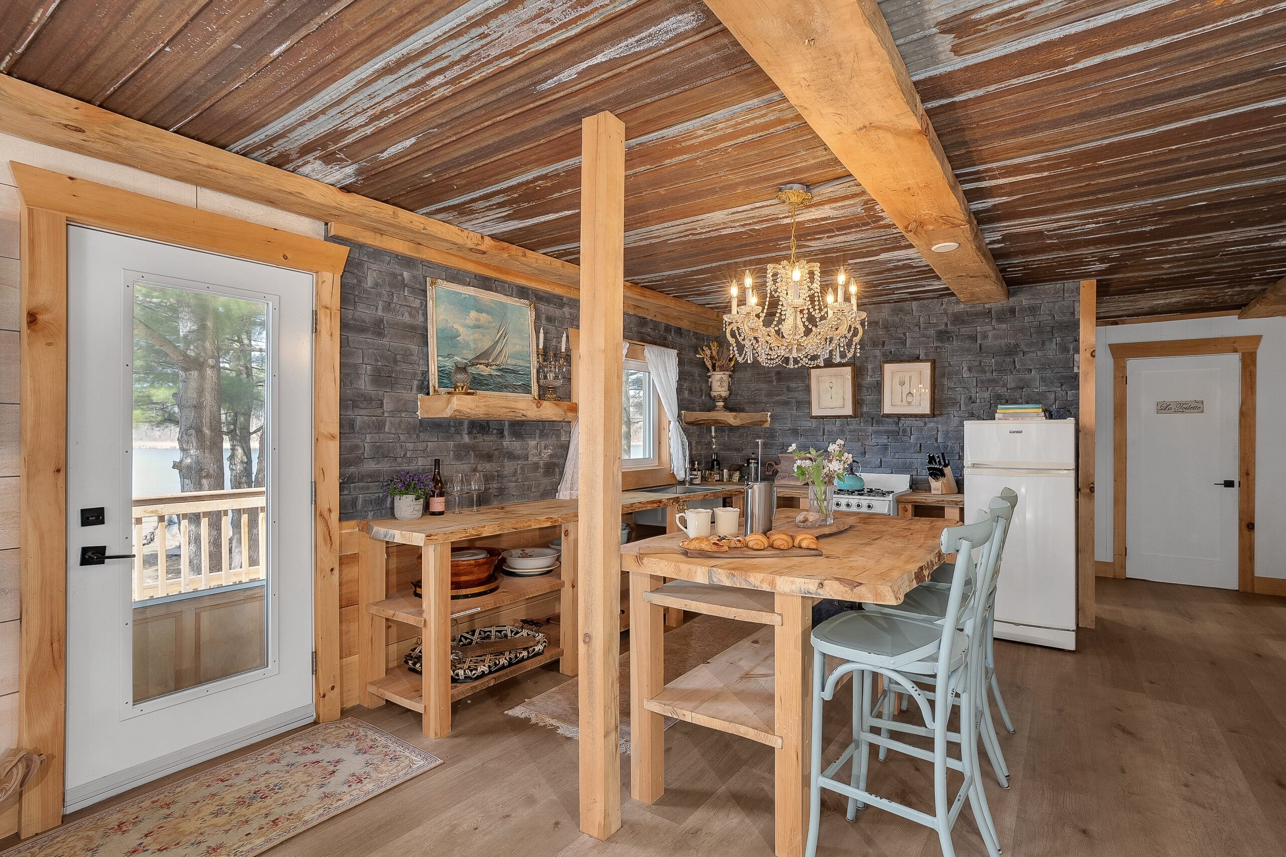 A white entrance door opens to a wide wood kitchen