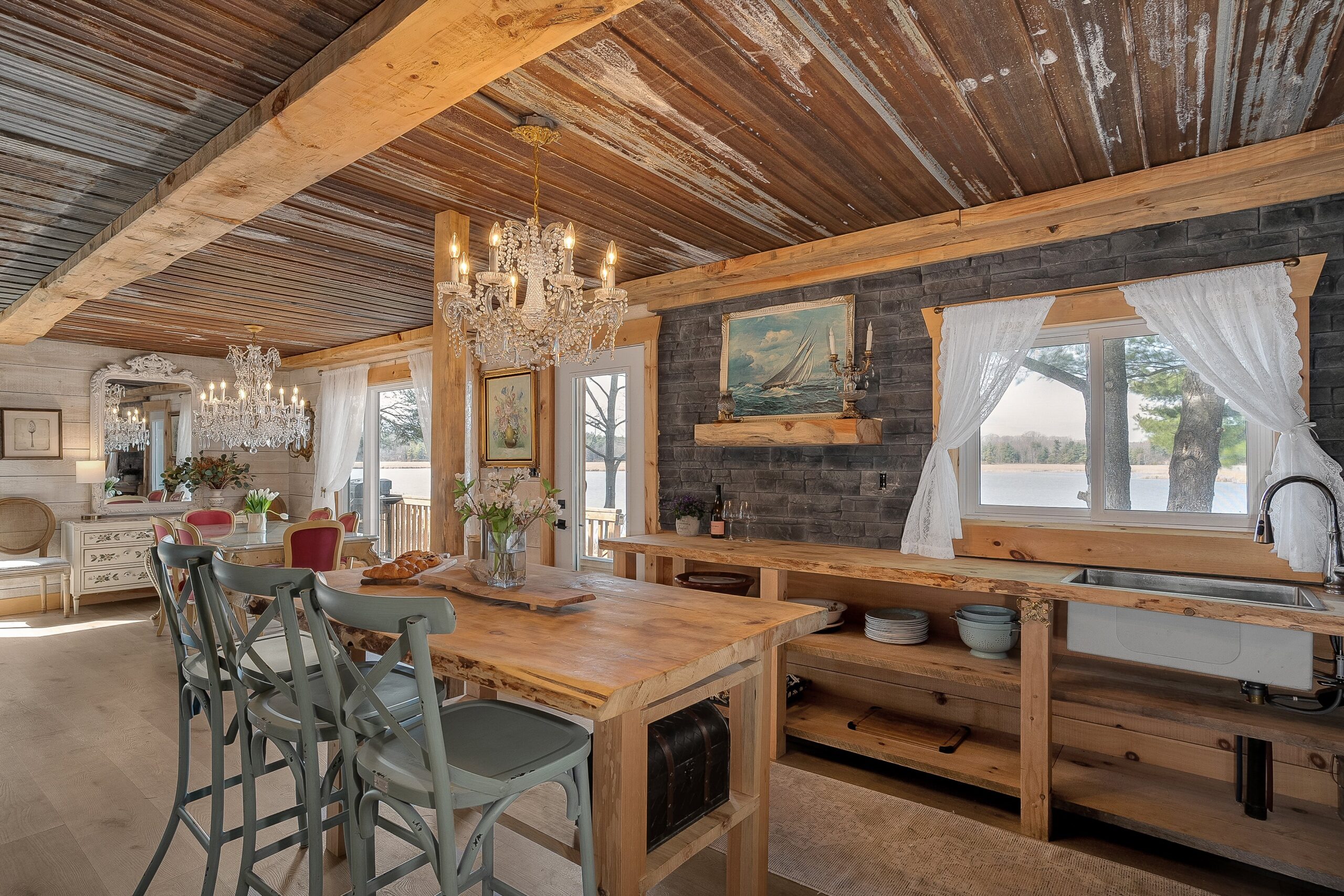 A wood kitchen island with two teal bar stools faces a wall of kitchen