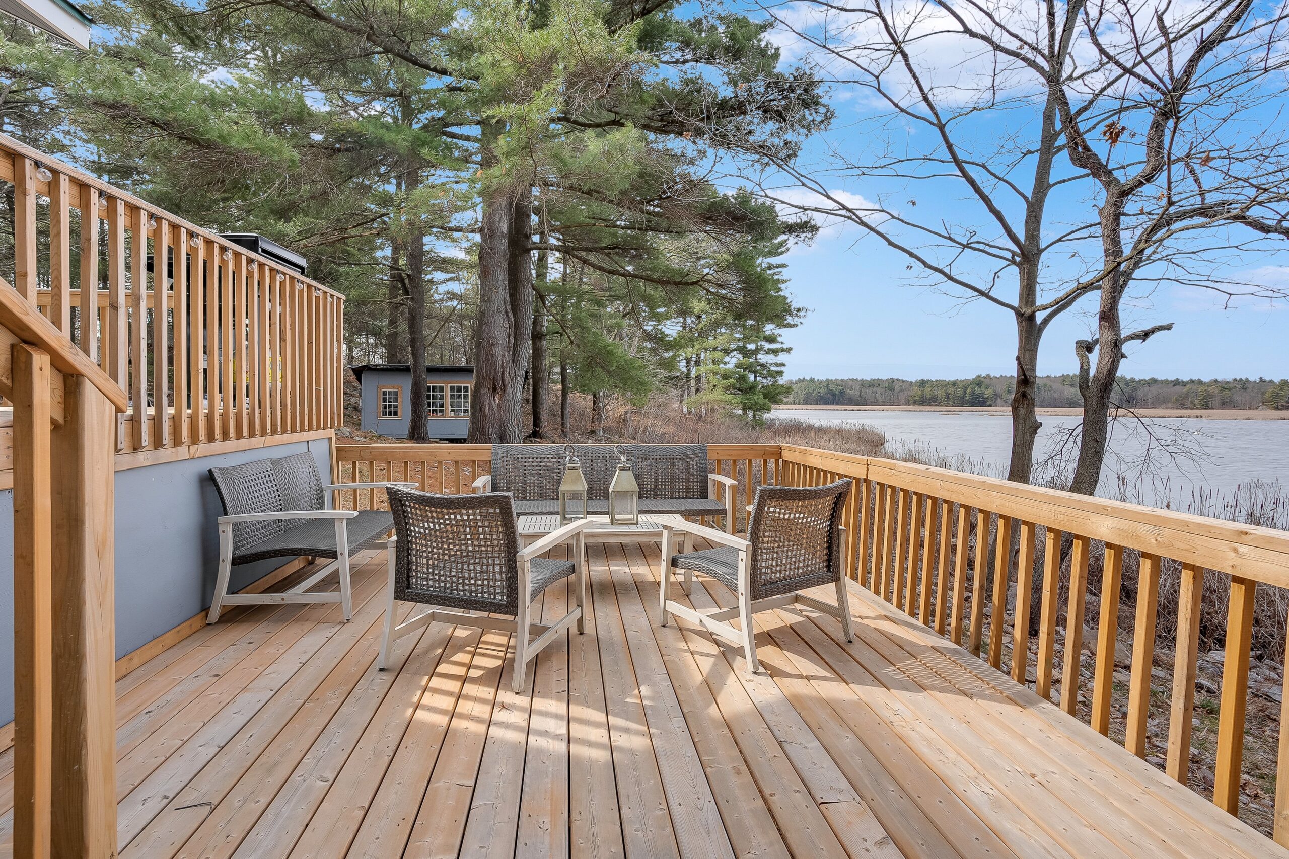Two chairs face a small couch on the deck