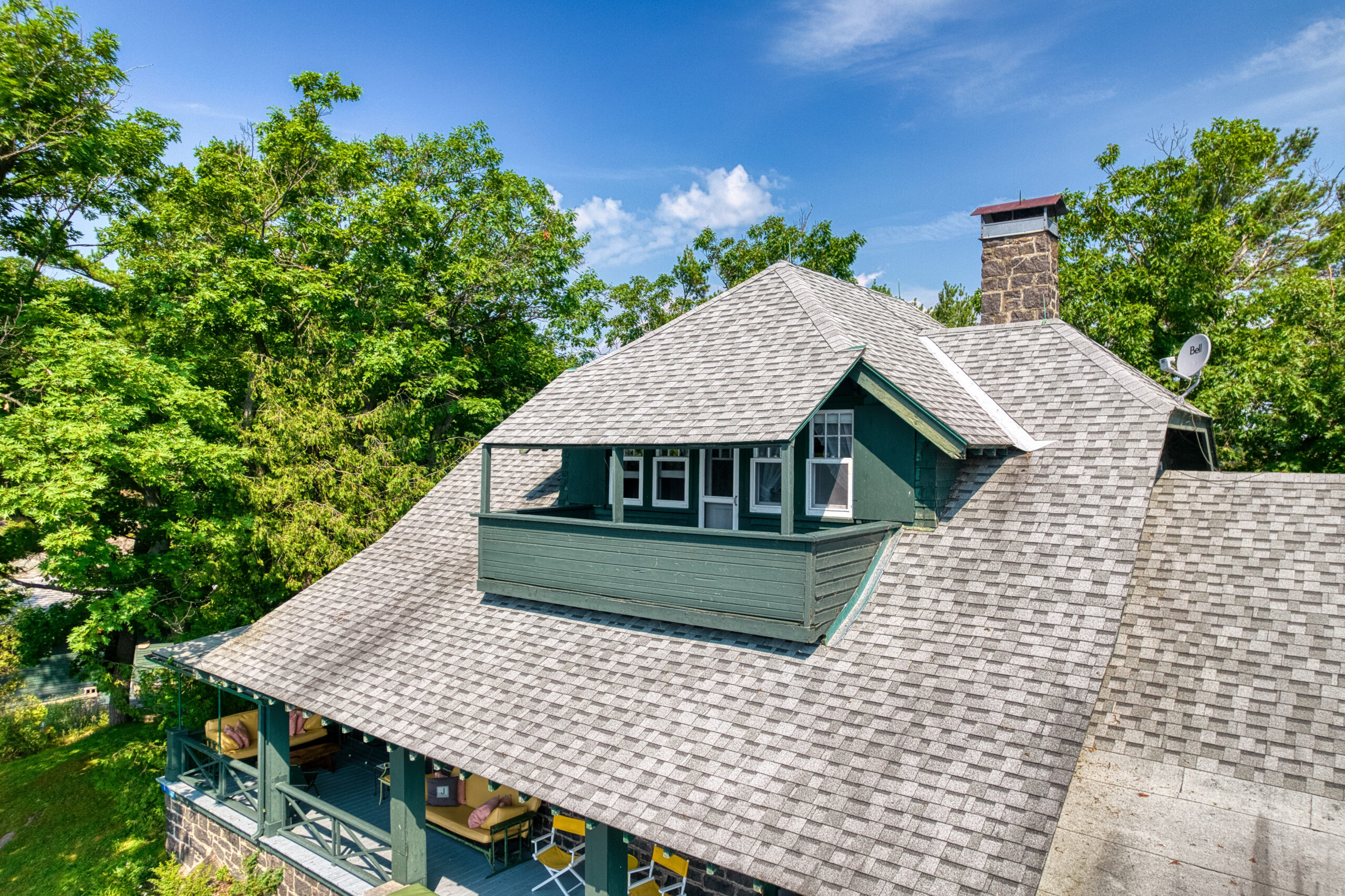 A green covered porch juts out from the top of the roof