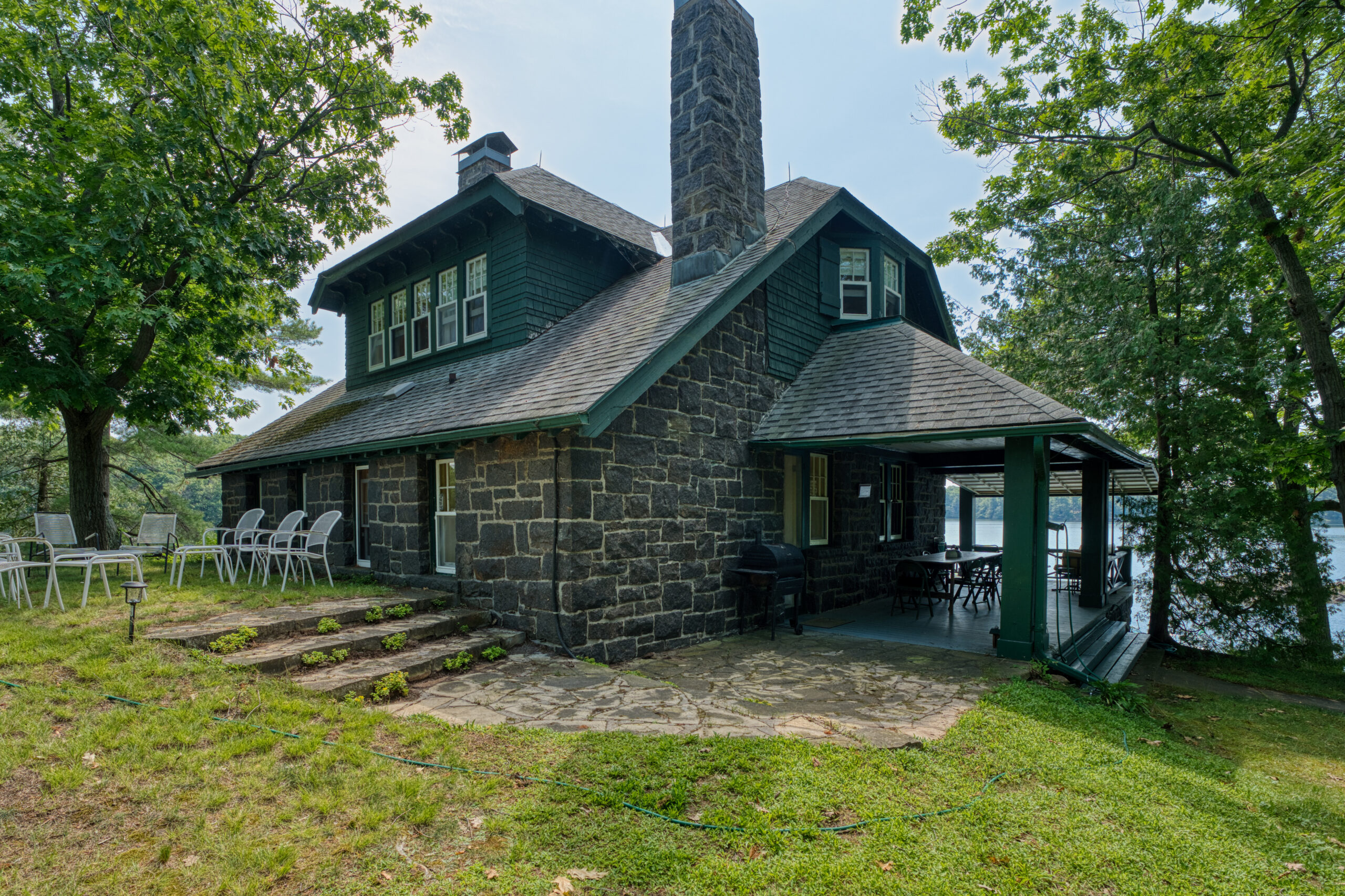 The side of the cottage features a covered dining area