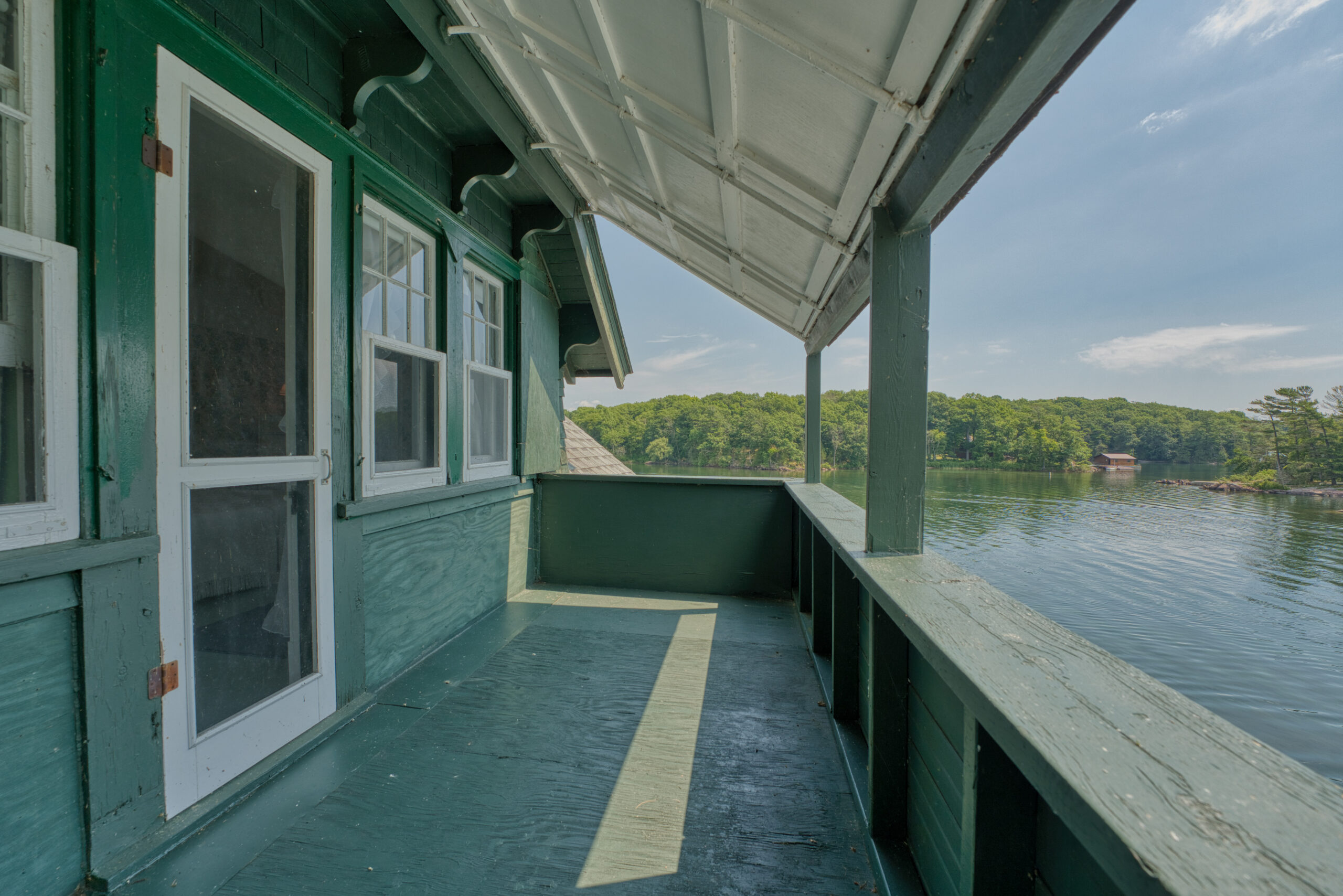 A green wood porch with lake views