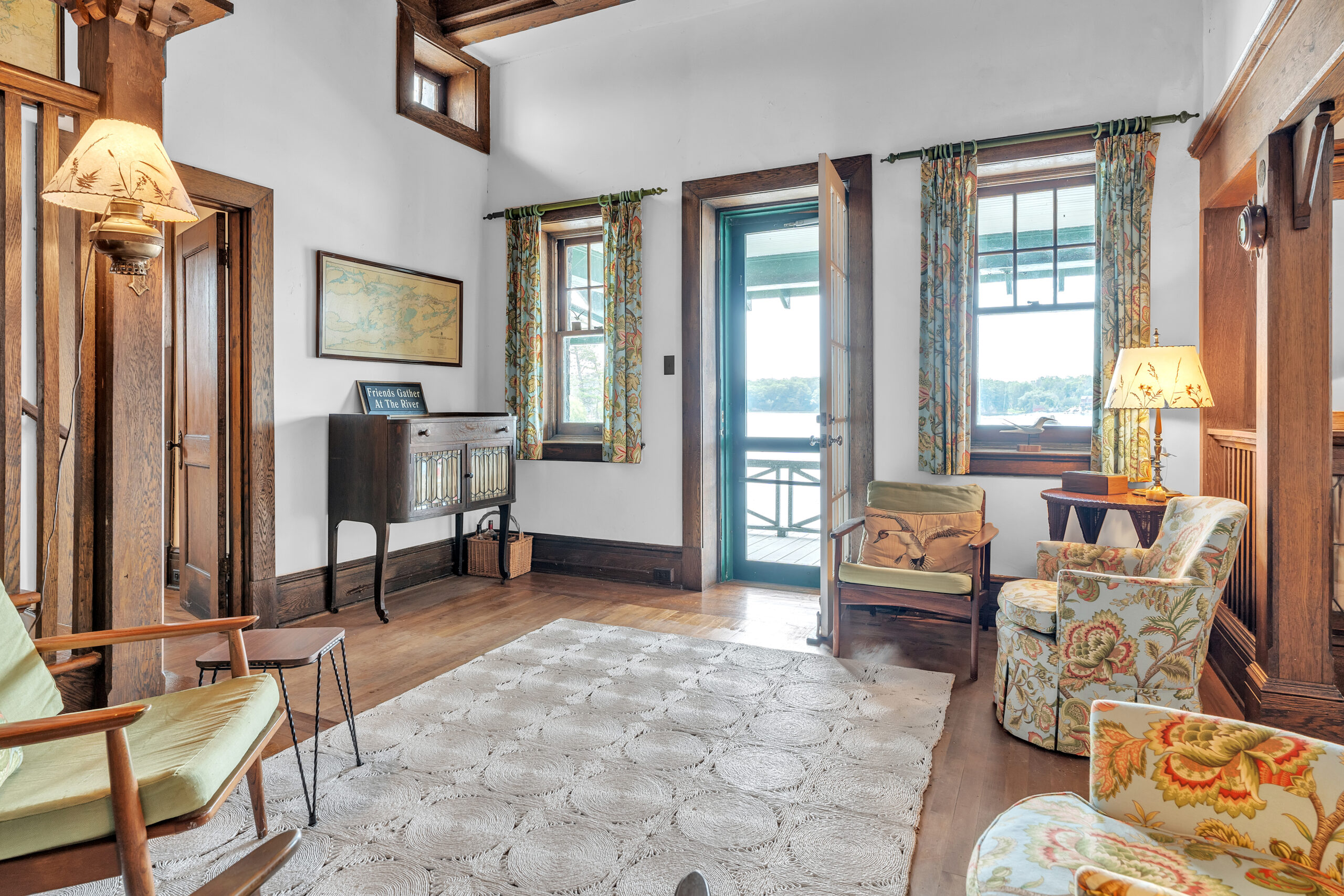 An open door sandwiched by two bright windows face a large cream carpet