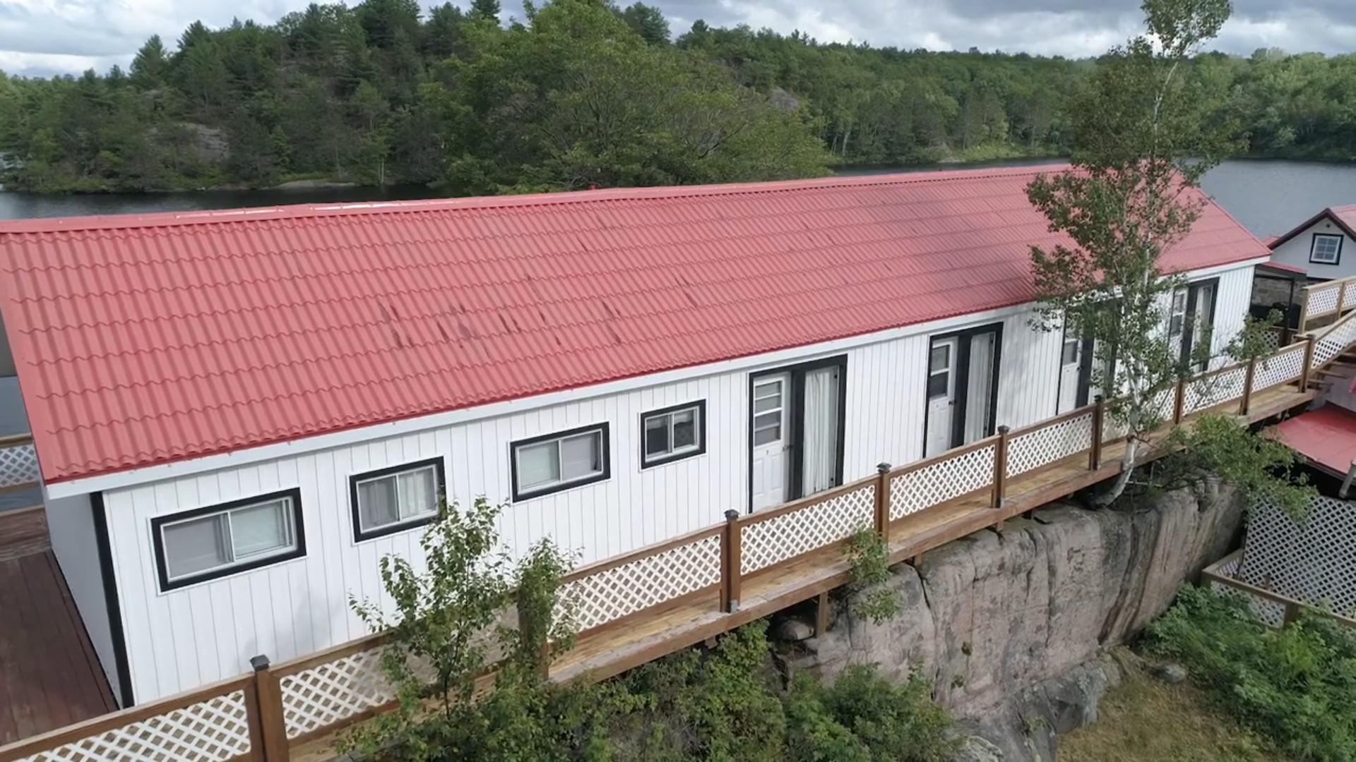 A long rectangular white-panelled building with a red roof