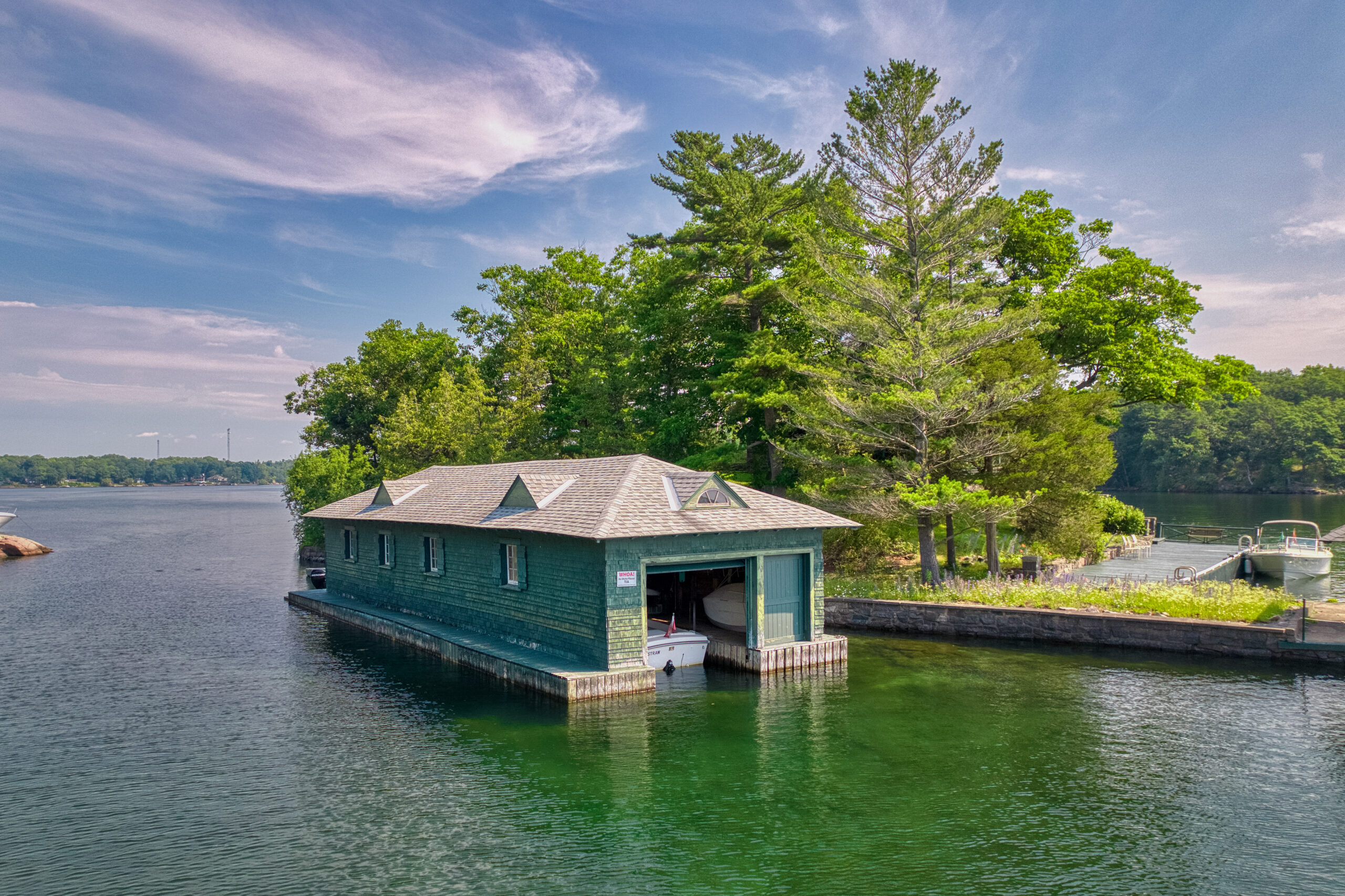 Open doorway to a long green boathouse in teh water