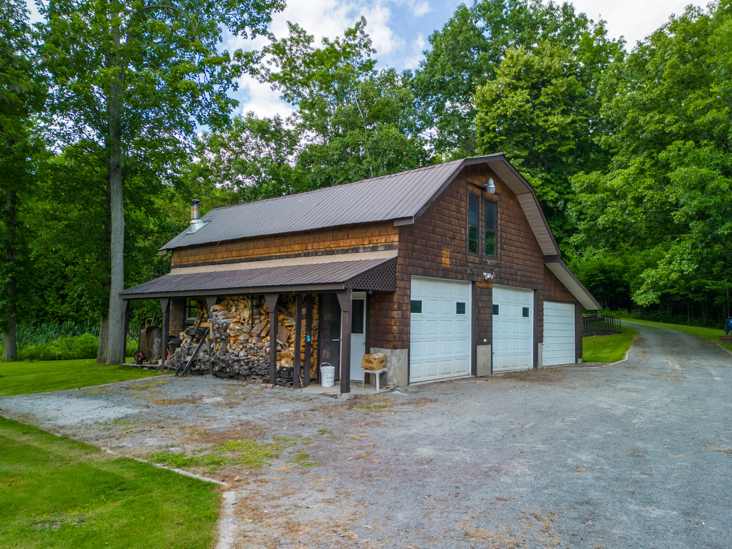 A large wood garage with three white doors