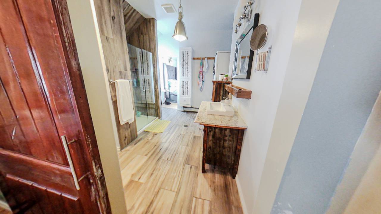 A walk-in shower faces a vanity and mirror