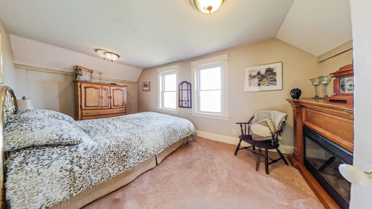 a bed is pushed against the wall in a white carpeted room