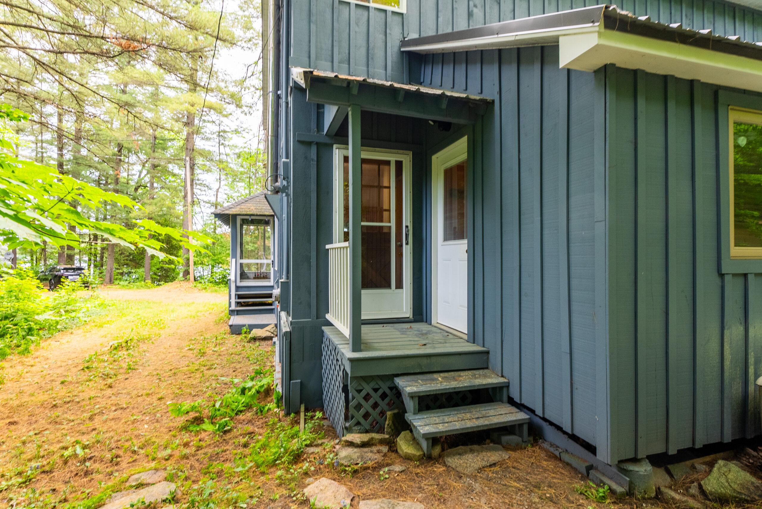 A small covered doorway outside the blue panelled cottage
