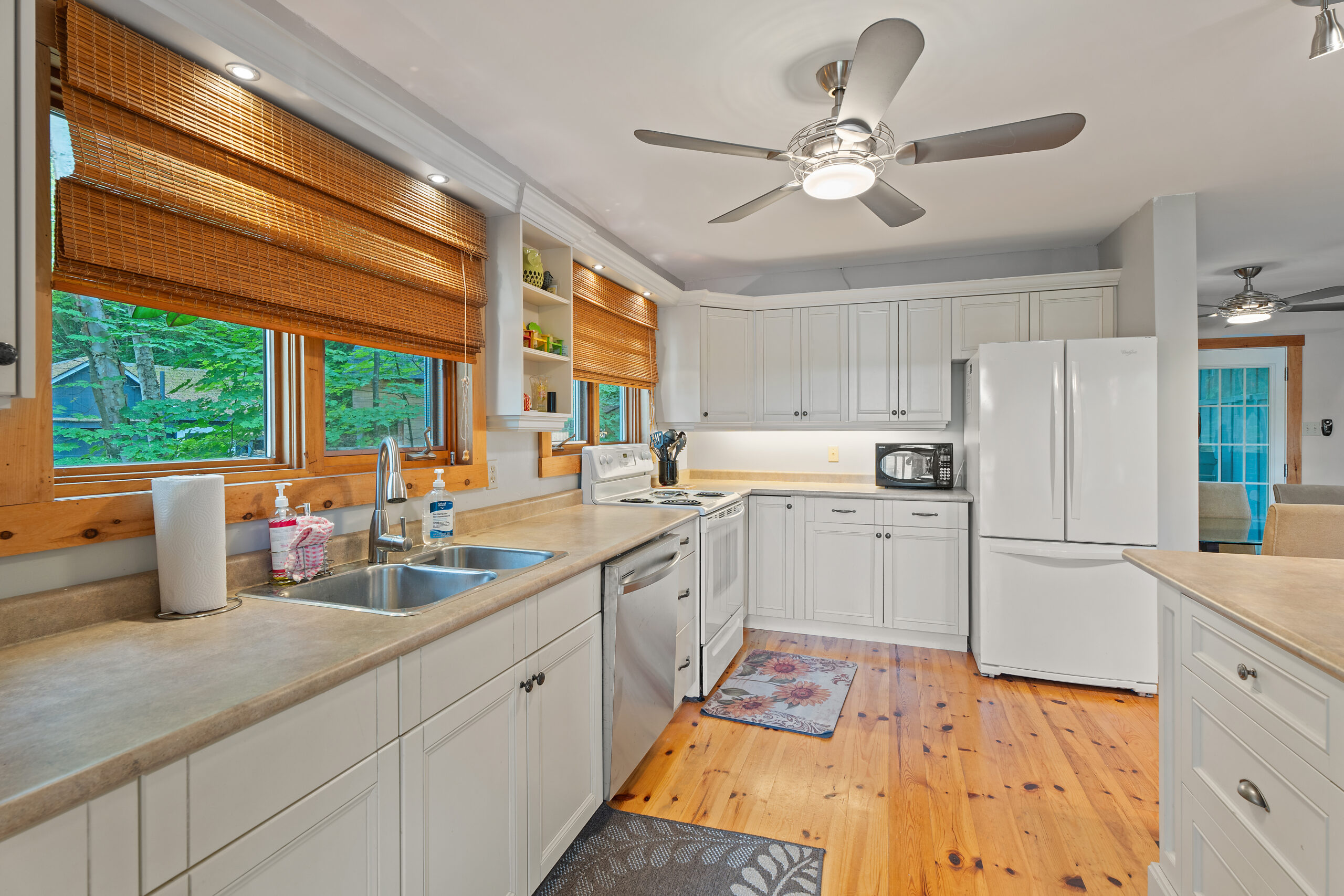White kitchen cabinets line a wall, perpendicular to more cabinets