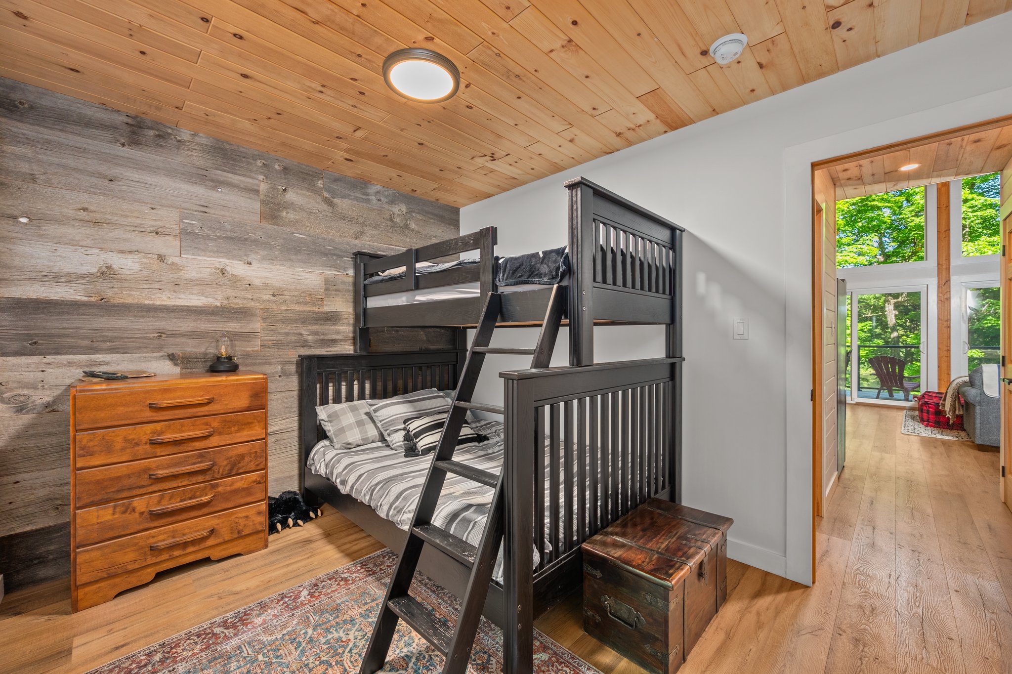 A black/brown bunk bed with grey bedspreads