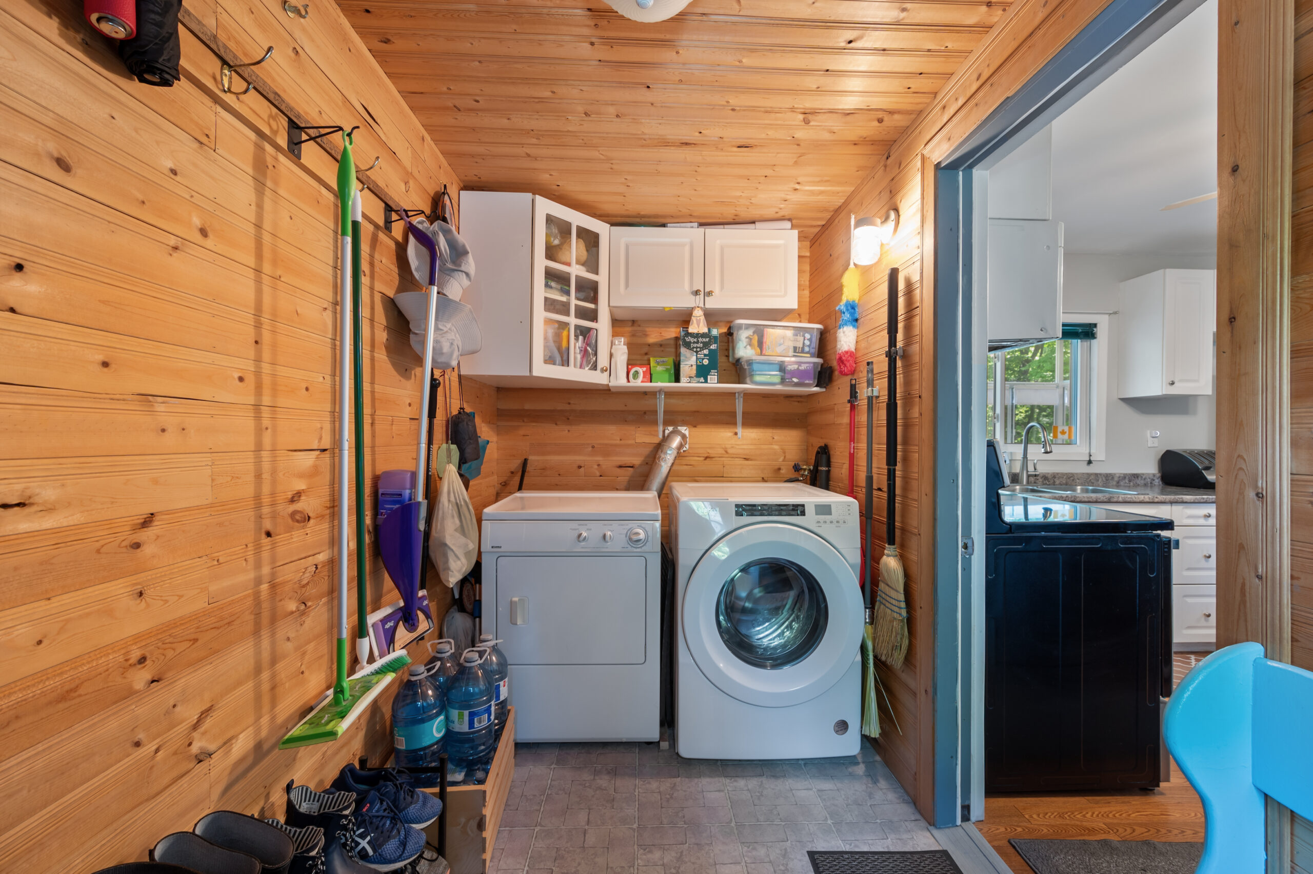 Laundry machines beside each other in a small wood-panelled room