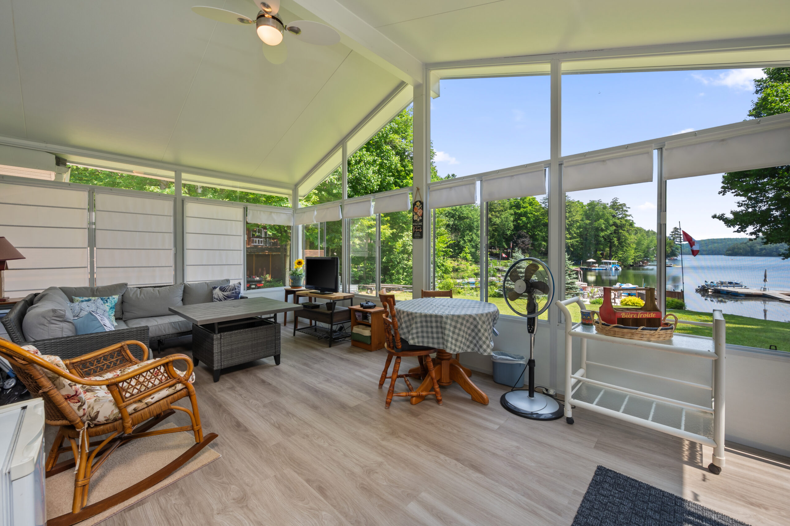 A glass wall that comes up to a point on the ceiling. To the left, a grey couch faces inside the room