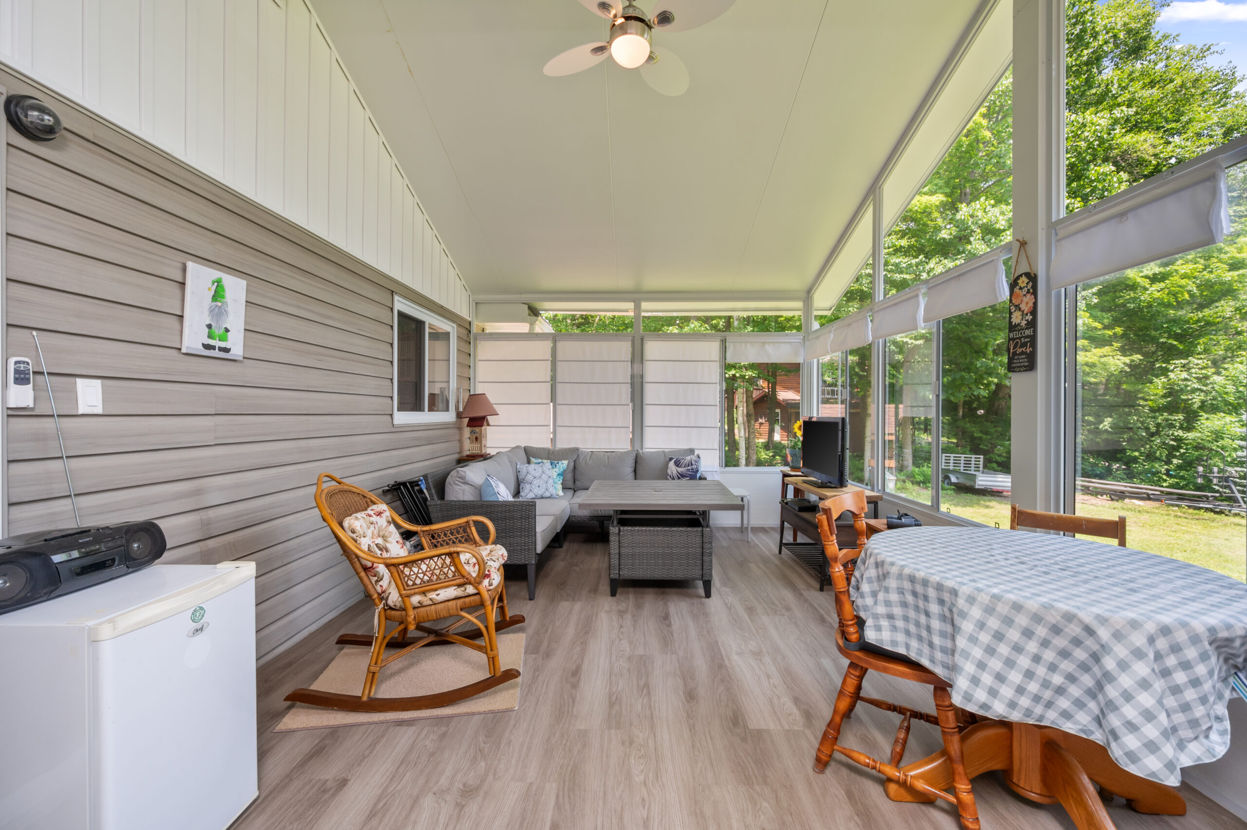 A grey couch next to a wooden rocking chair