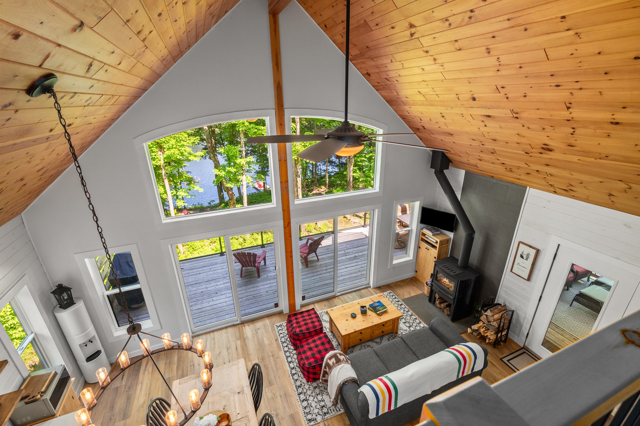 From above, a grey couch faces a wood coffee table and huge windows