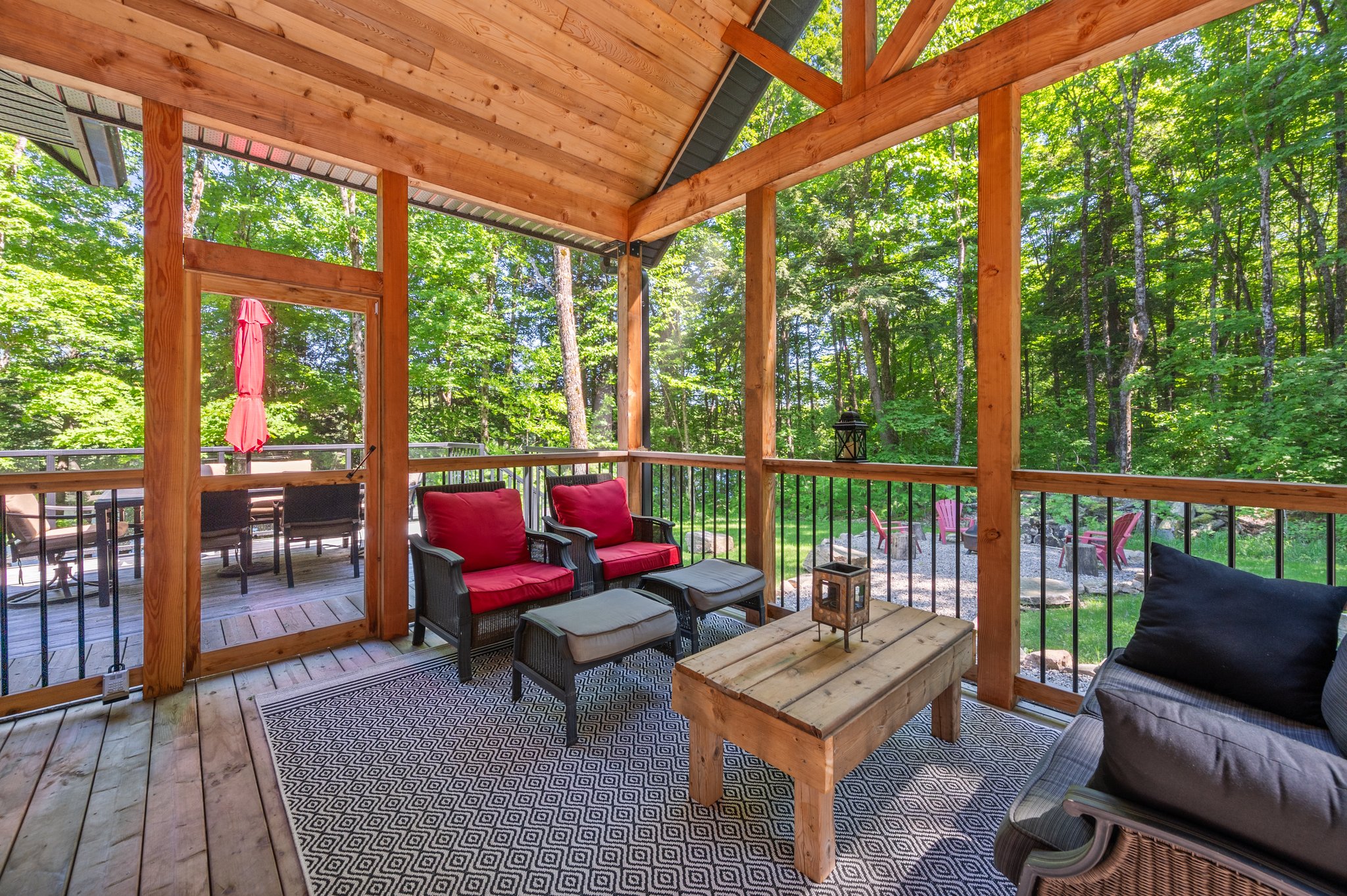 A sitting area with two chairs and a table in a screened-in room