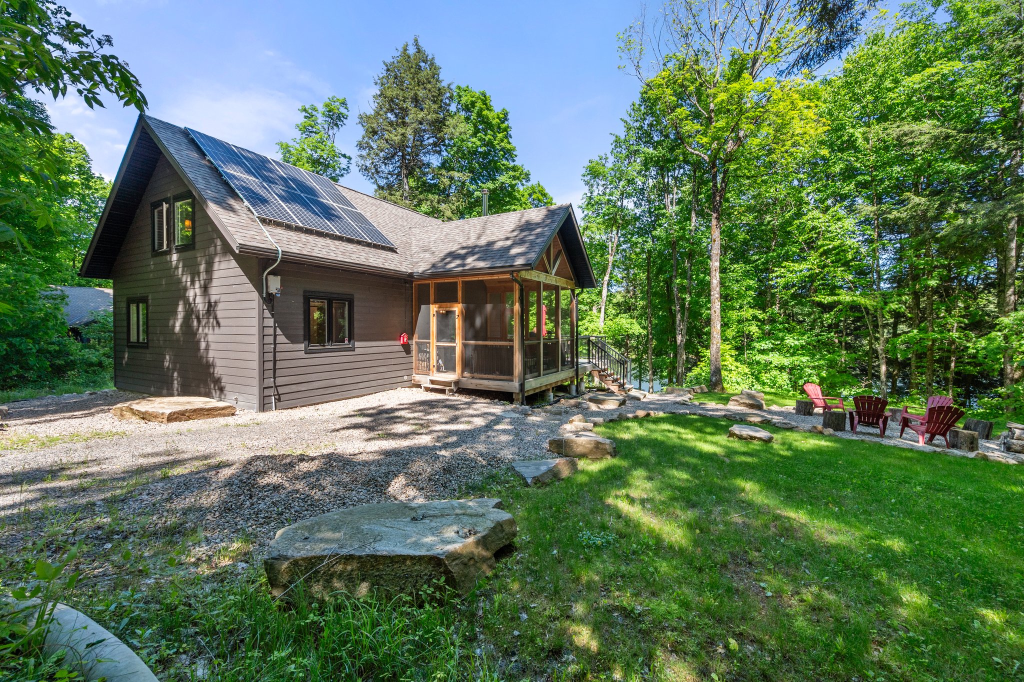 A grey panelled cottage near a grassy lawn