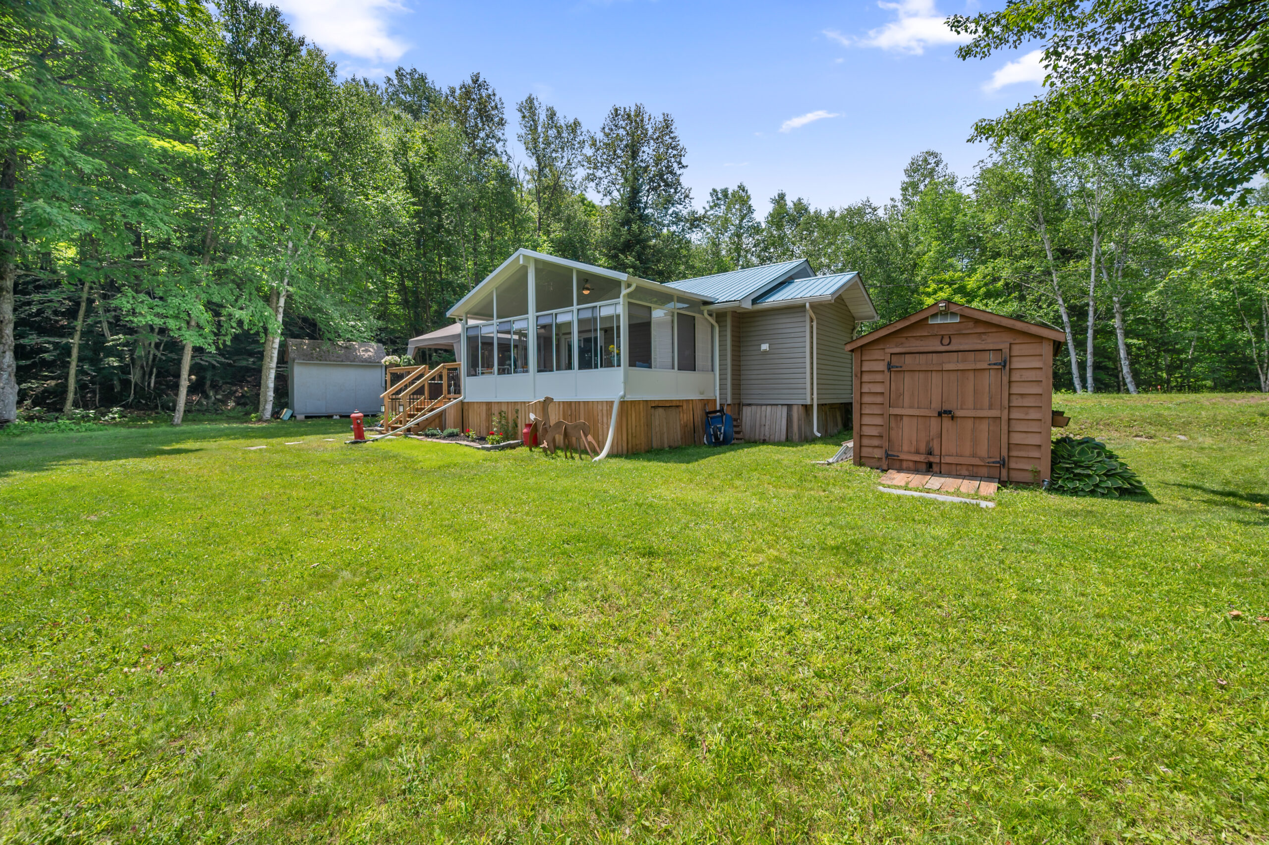 The front of the cottage with a small brown shed nearby