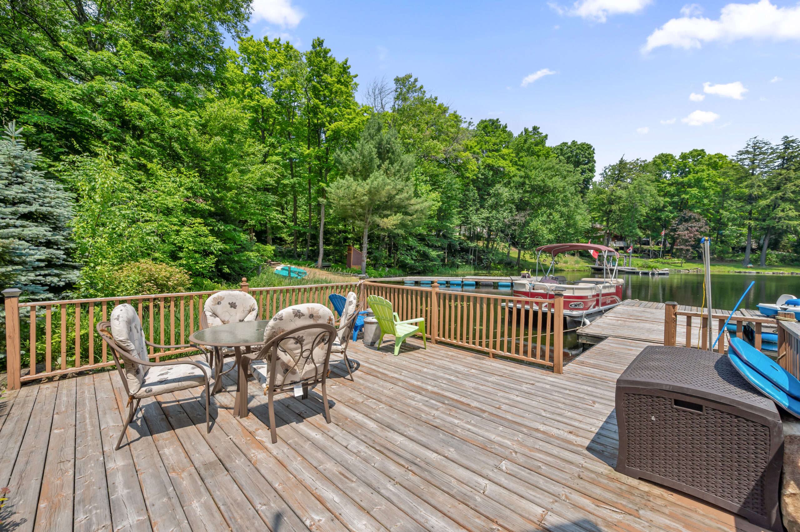 A deck with a small seating area next to the water