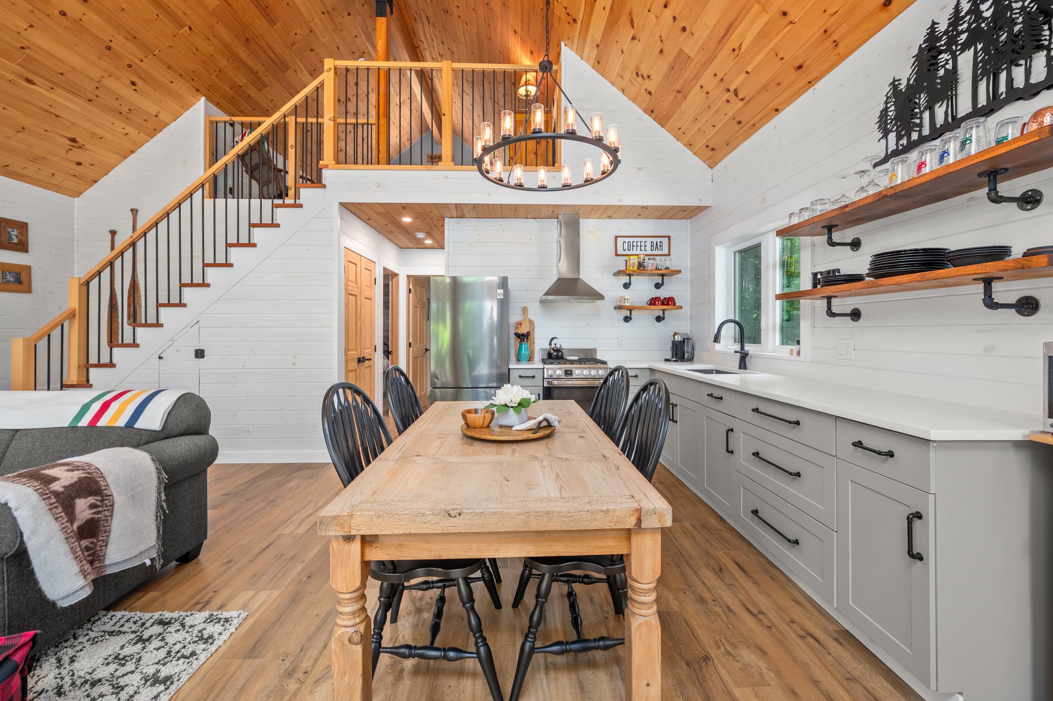 From the end, a wood table with grey chairs in a kitchen with grey cabinets