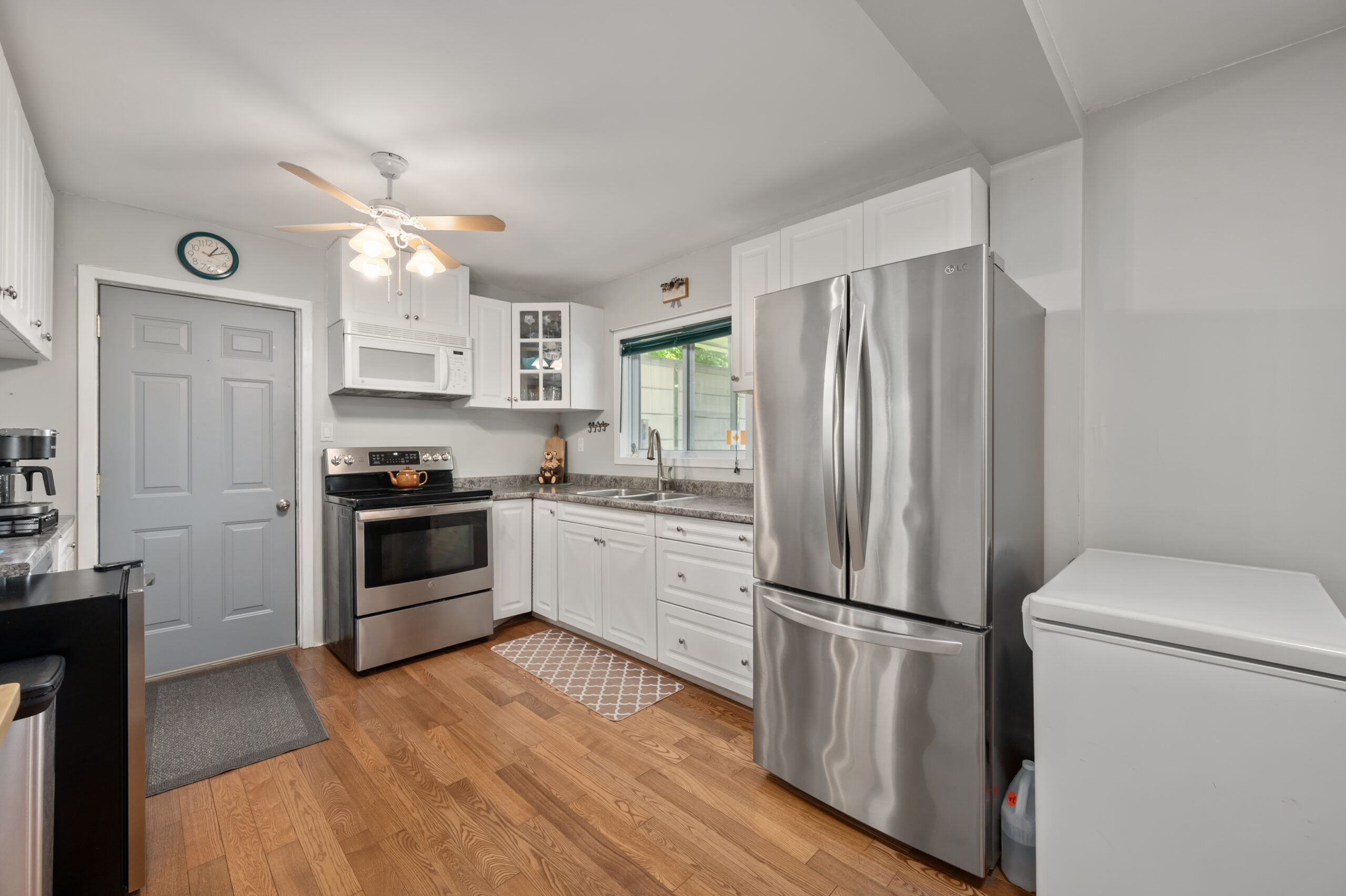 A stainless steel fridge beside white cabinets