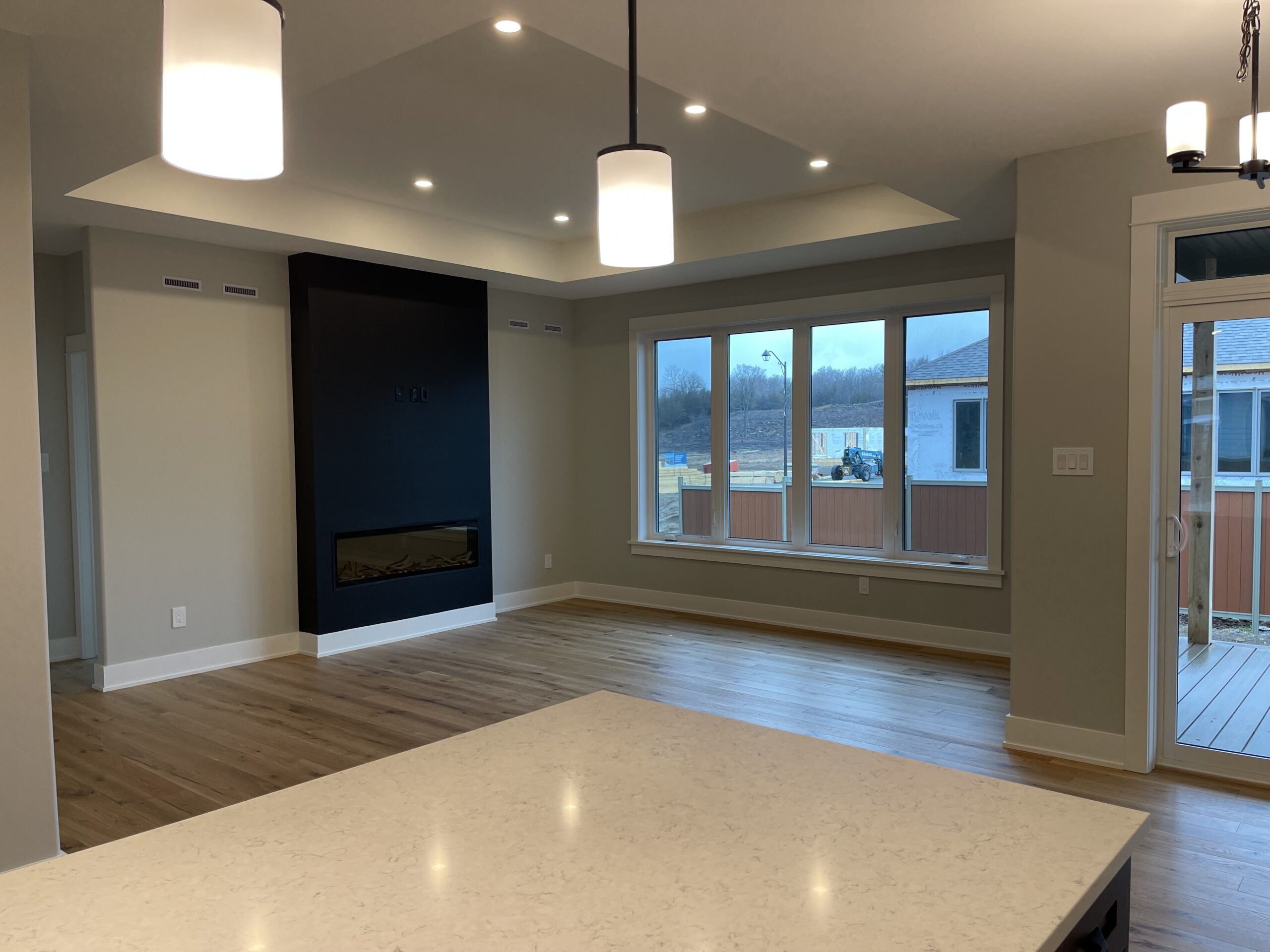 From the kitchen, a large empty space with a fireplace