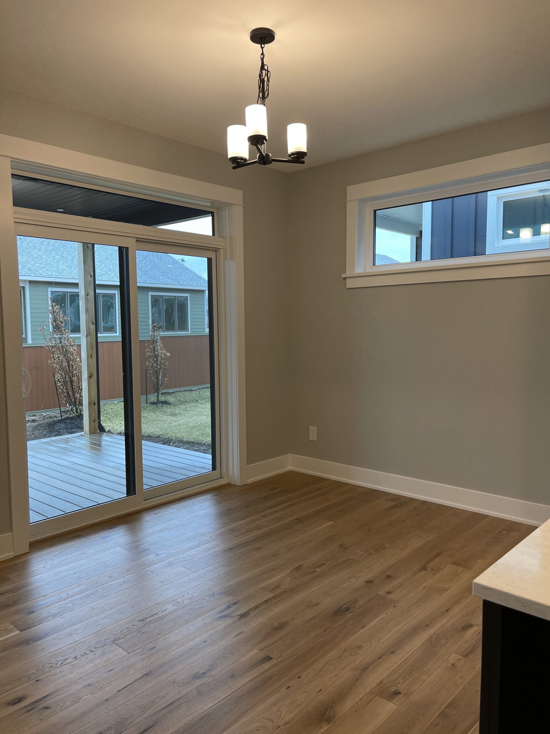 An empty space with glass doors that open to the backyard