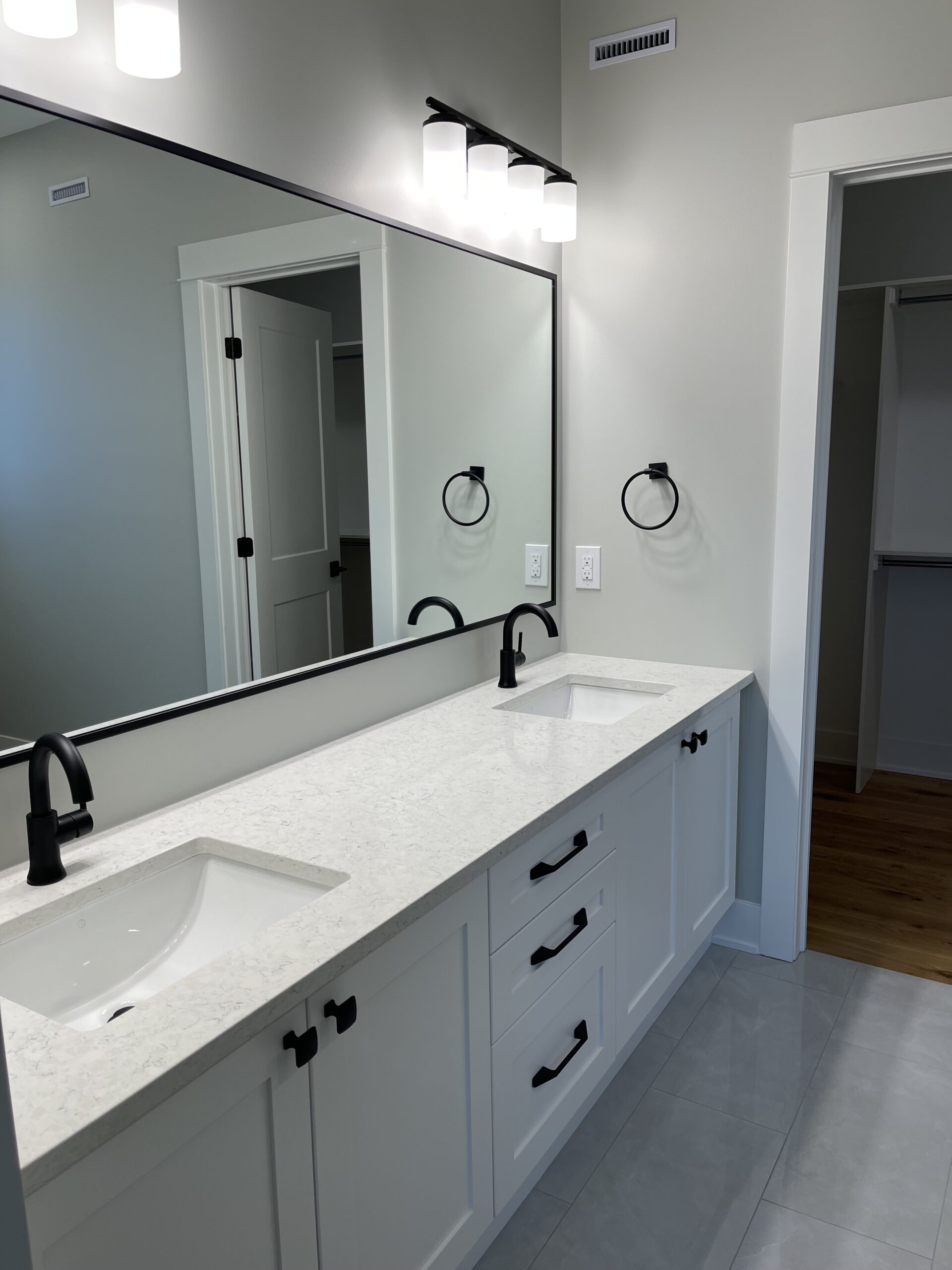 A double-sink with a large mirror hanging above