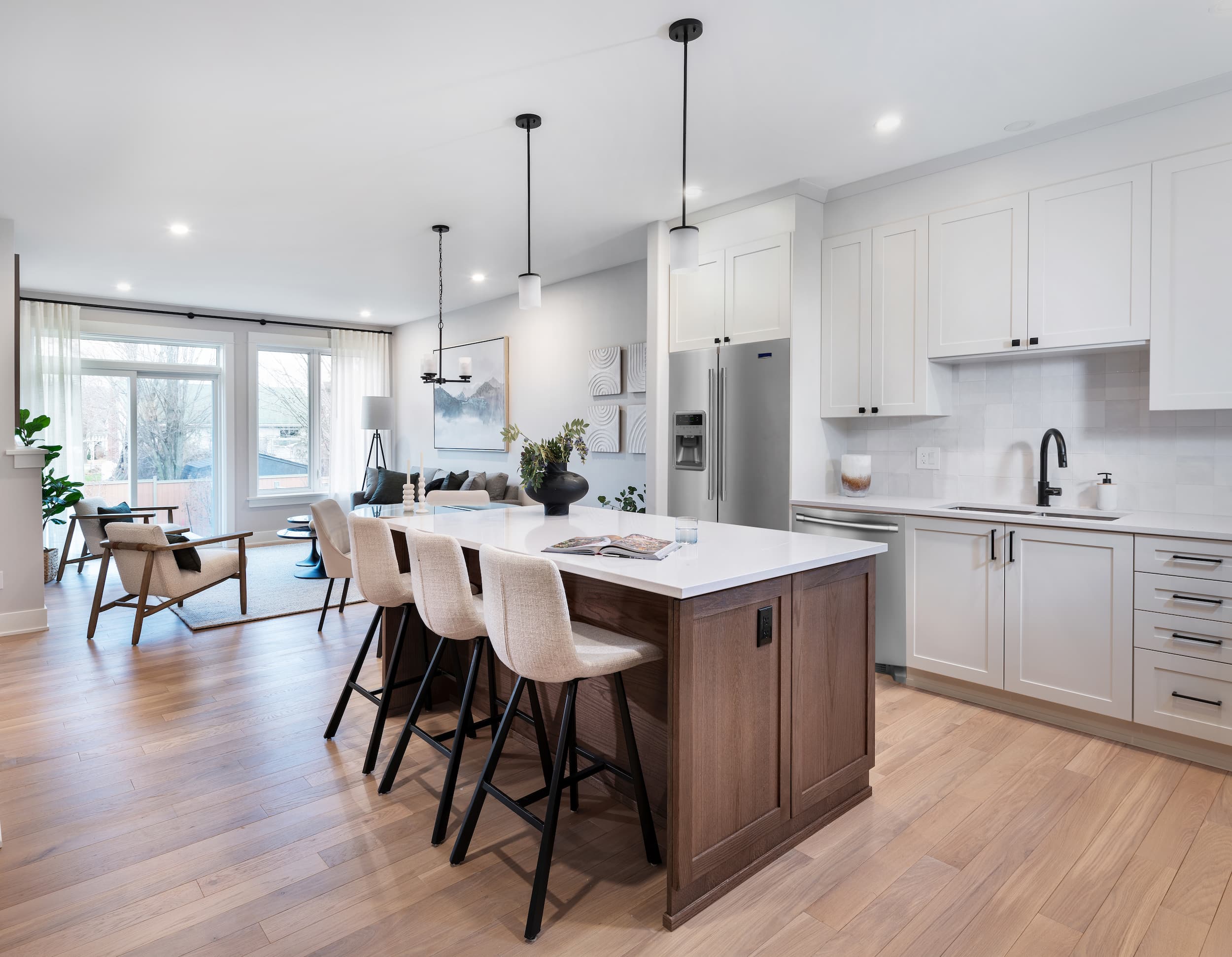 A large brown kitchen island with white countertops and white bar stools