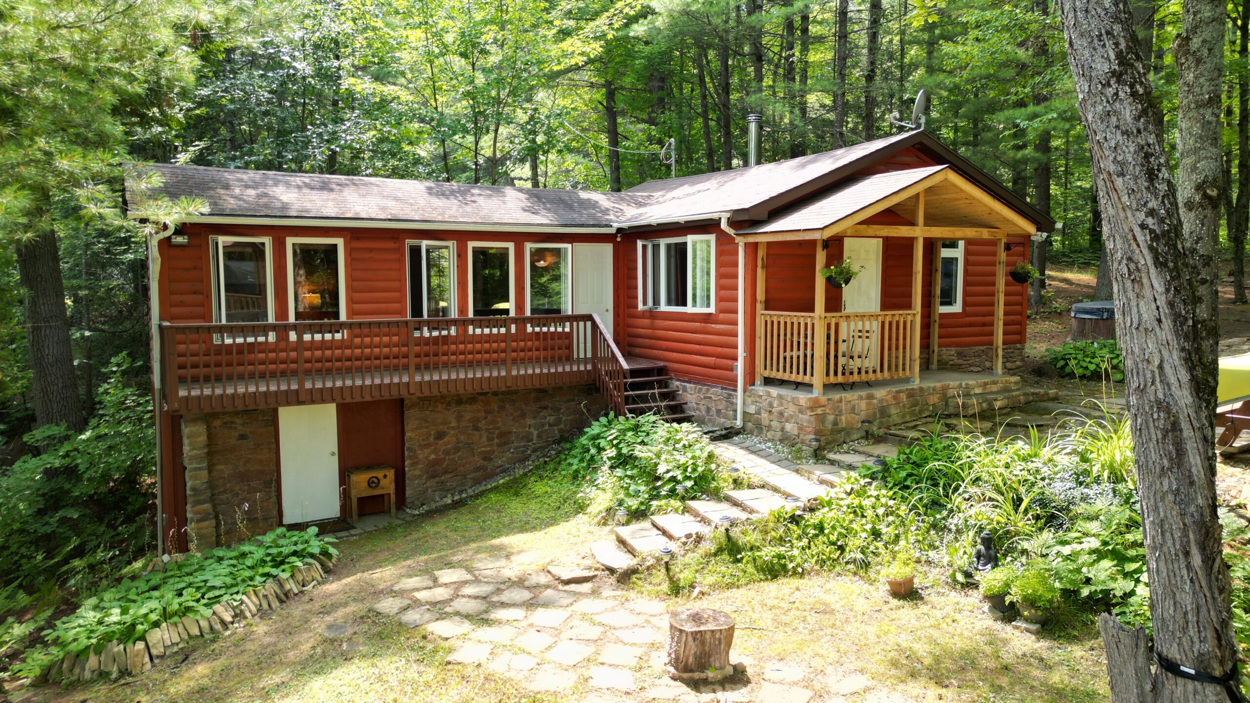 A red panelled bungalow cottage with steps leading up to the front door