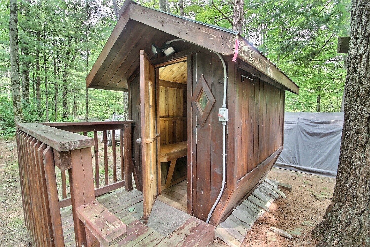 A small wood building with the front door open