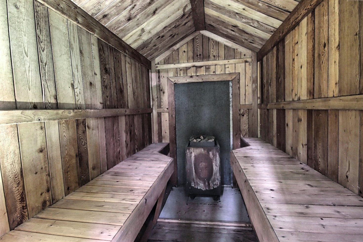 Inside a sauna, two wood benches face each other