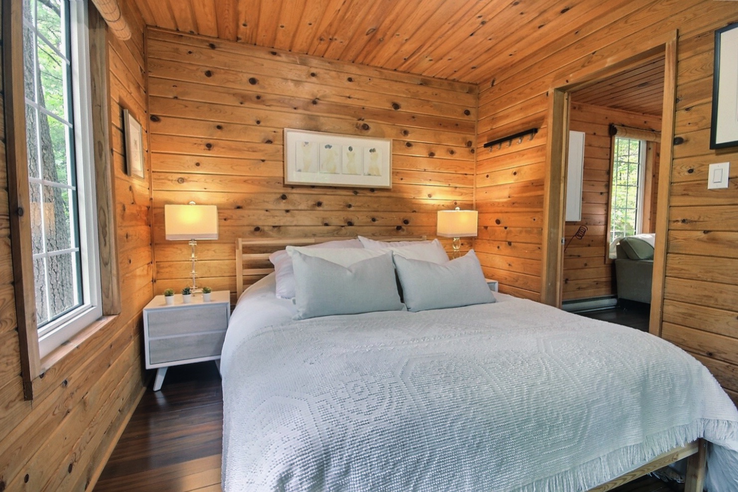 A large white bed in a wood panelled room