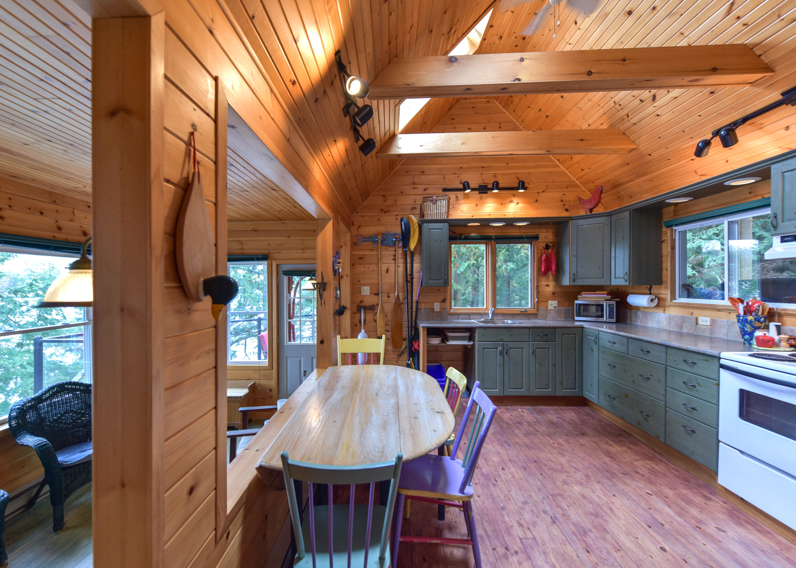A rounded wood table next to an open space in the kitchen