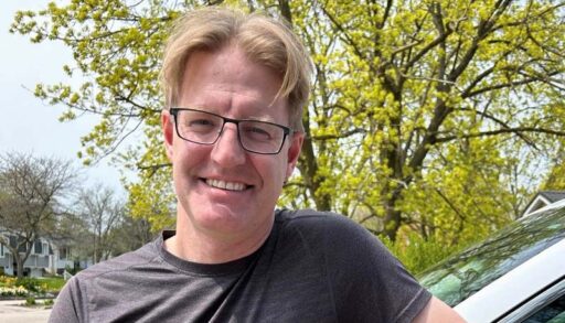 A man standing beside his weather vehicle