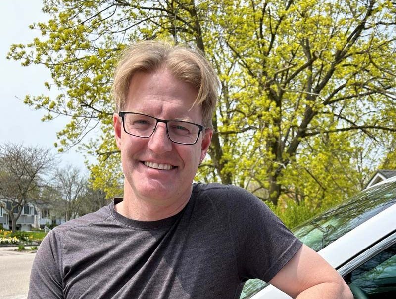 A man standing beside his weather vehicle