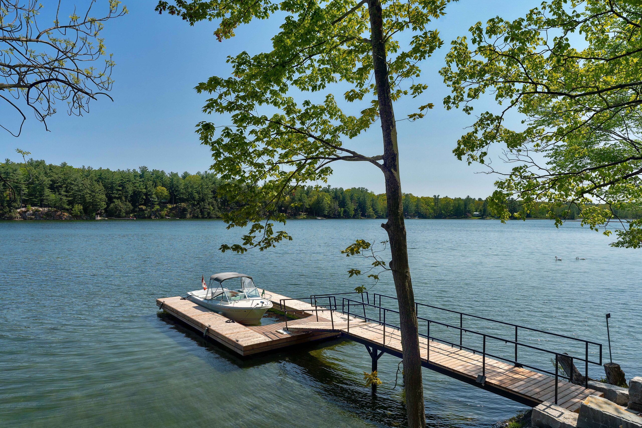 A long dock in the water with a boat parked in the middle