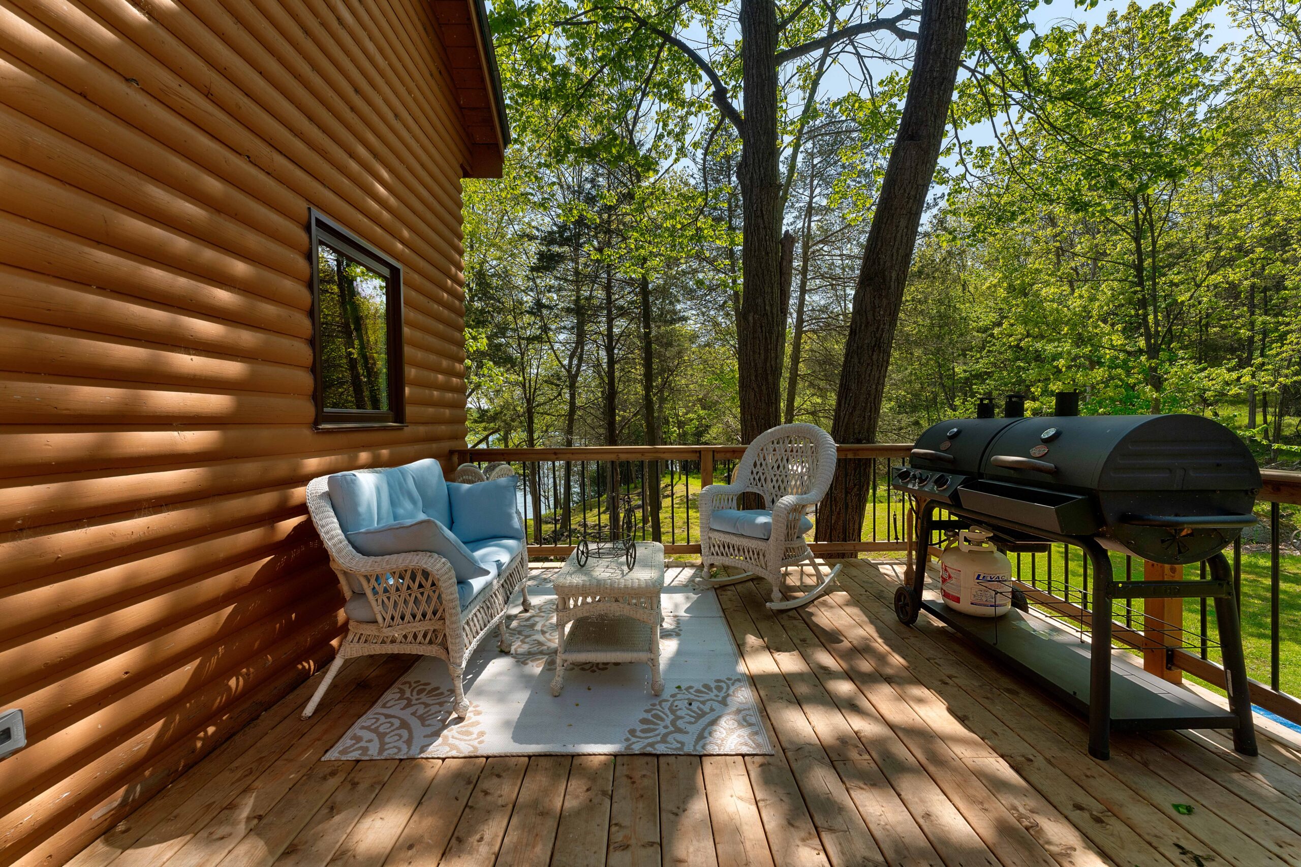 Wicker chairs face each other on a wood deck