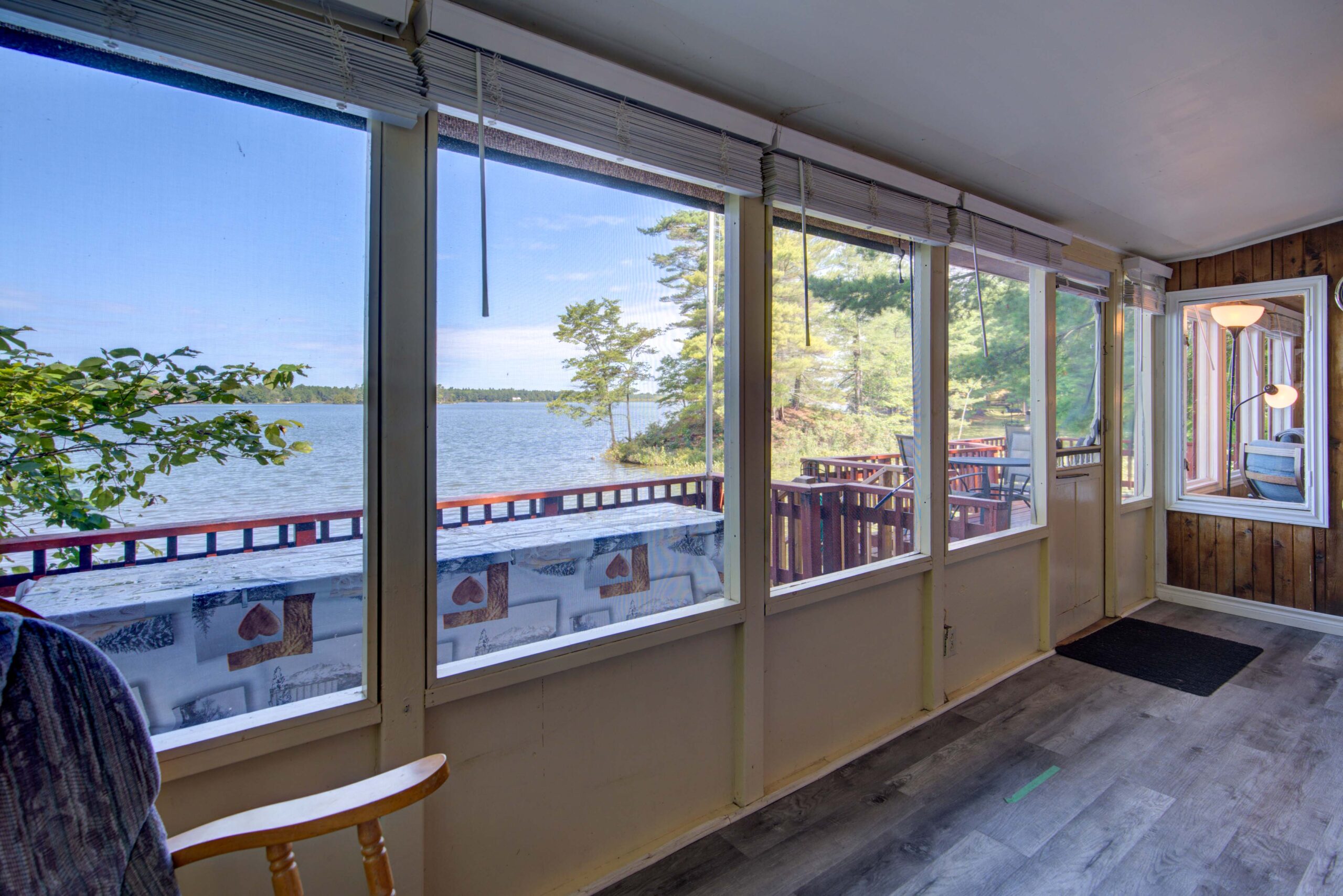 Large windows face a red deck and a lake