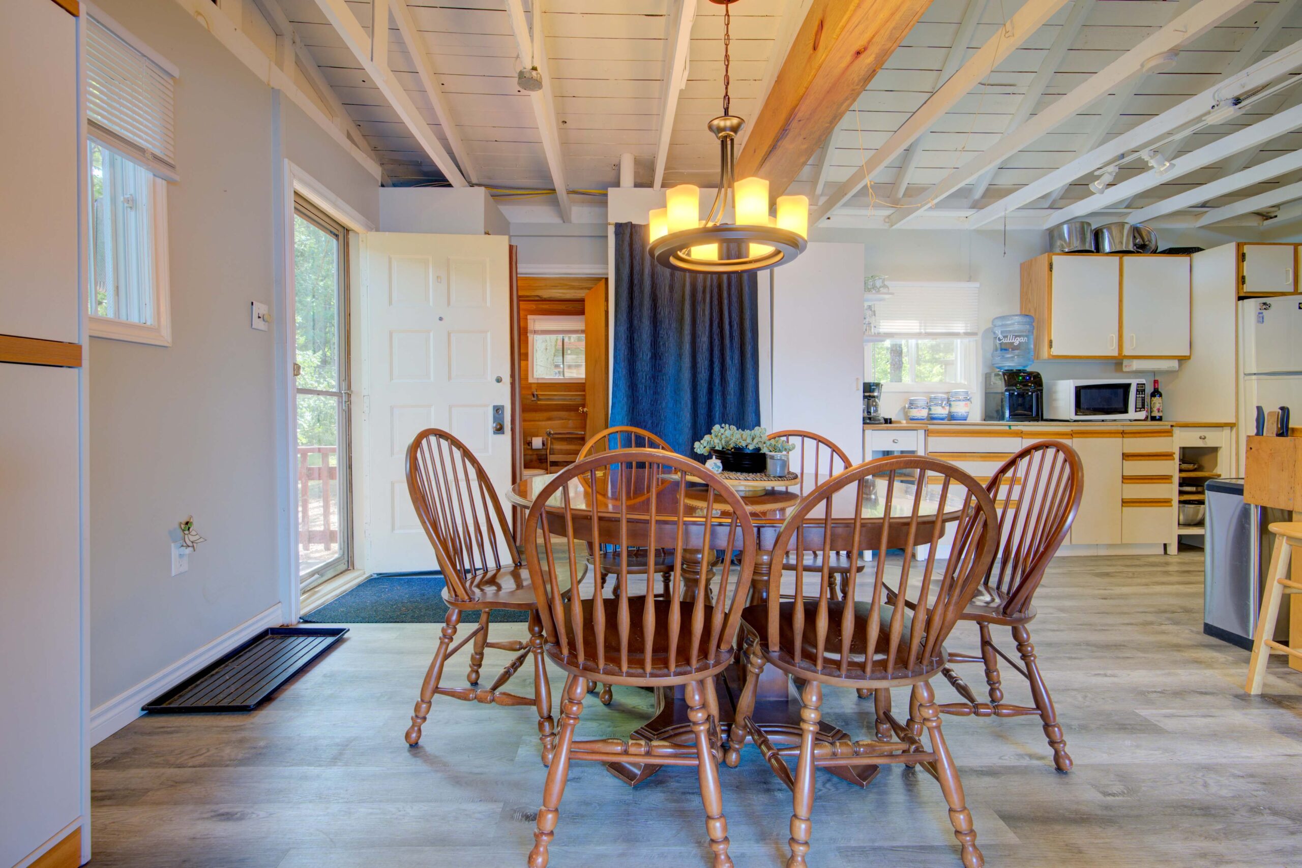 A wood dining table with wood chairs in a white room