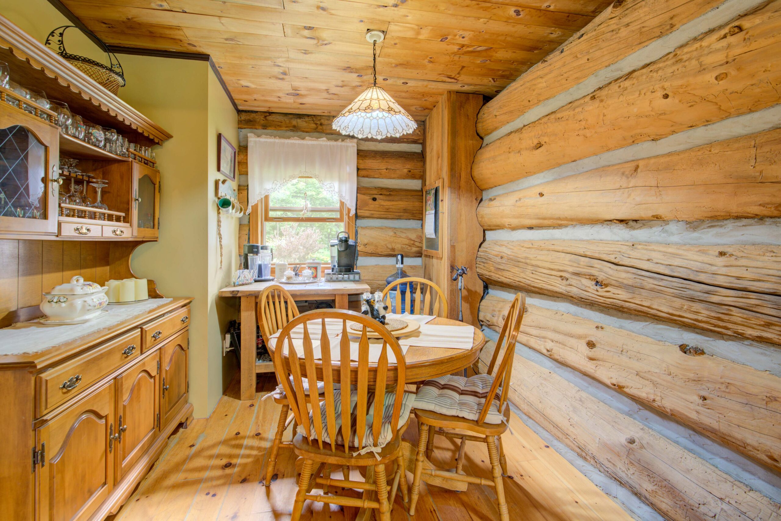 A wood-paneled room with a small wood table and wood chairs