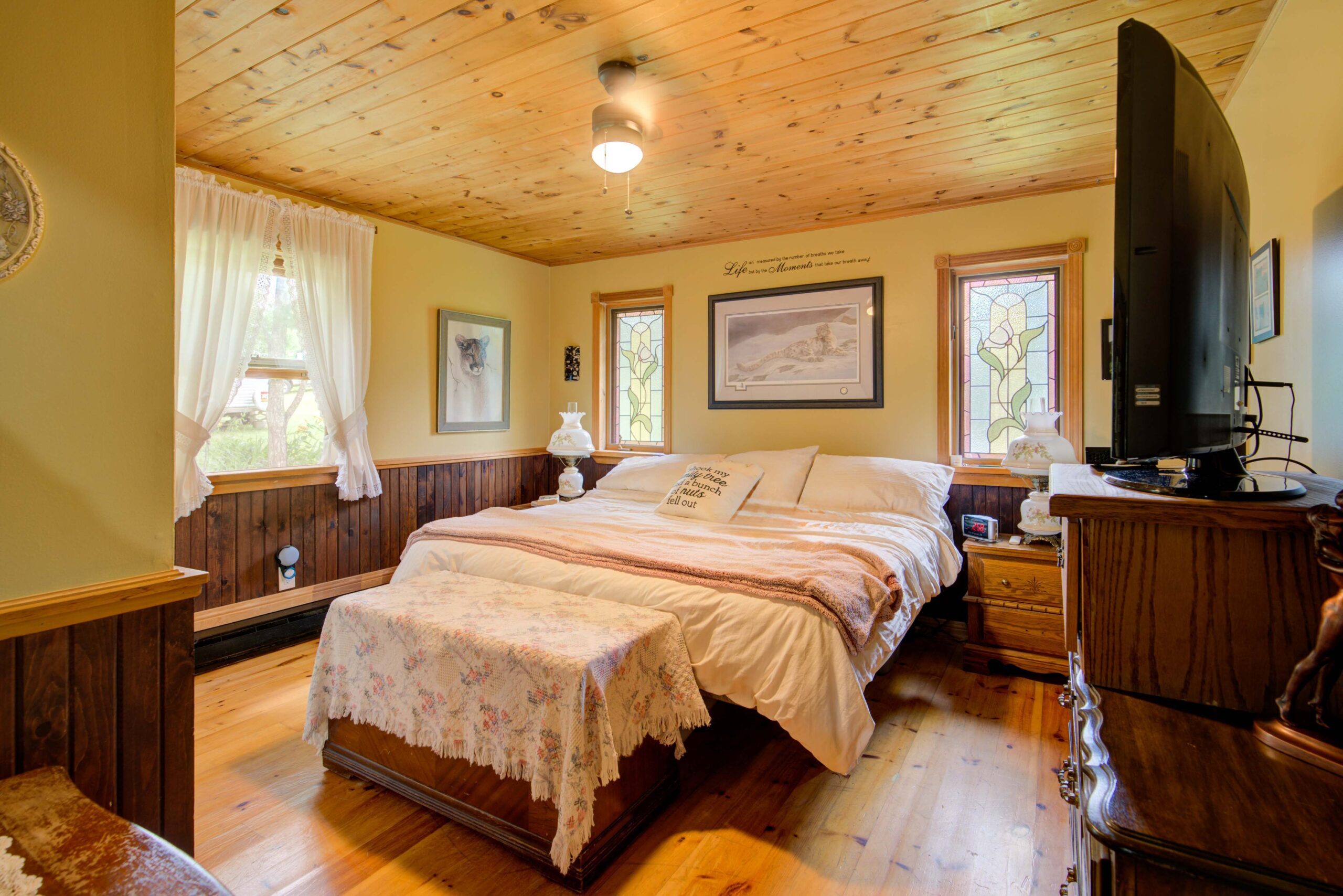 A large white bed in a wood-paneled room